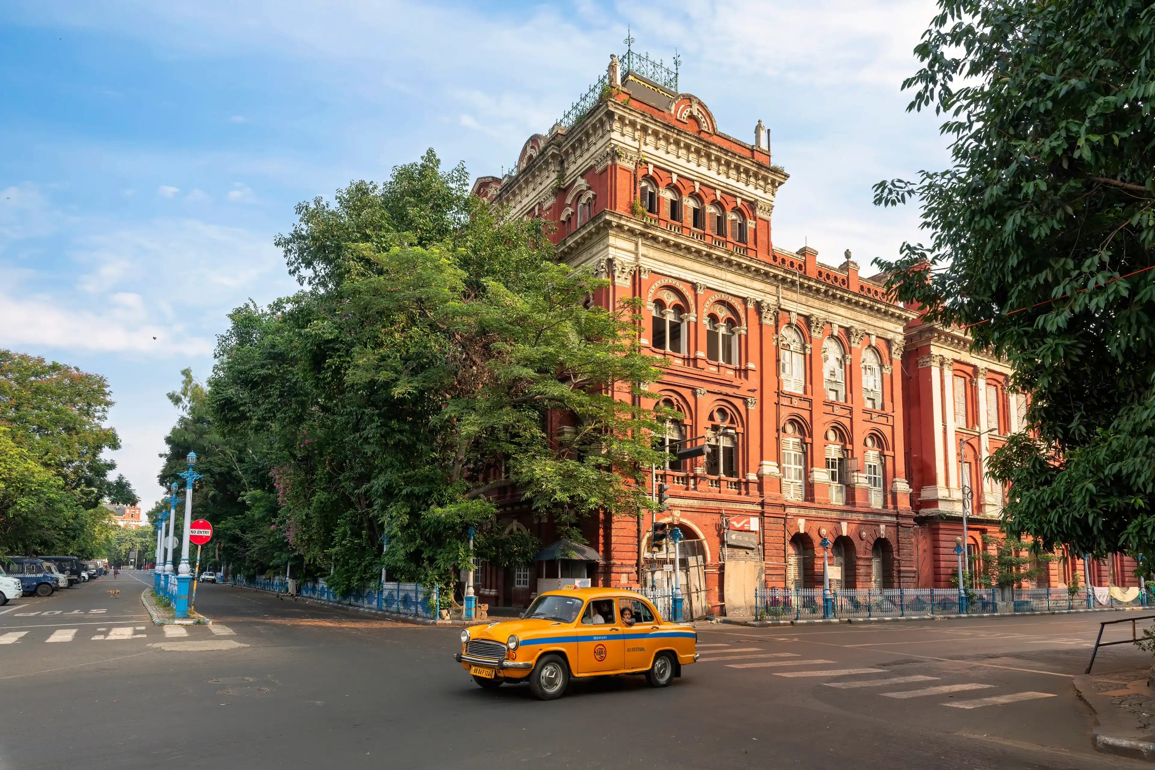 Ancient Writers' Building built in the colonial era with a view of a yellow taxi on the city road in the morning in Kolkata, India, photographed on July 3, 2024 Ancient Writers' Building built in the colonial era with a view of a yellow taxi on the city road in the morning in Kolkata, India, photographed on July 3, 2024