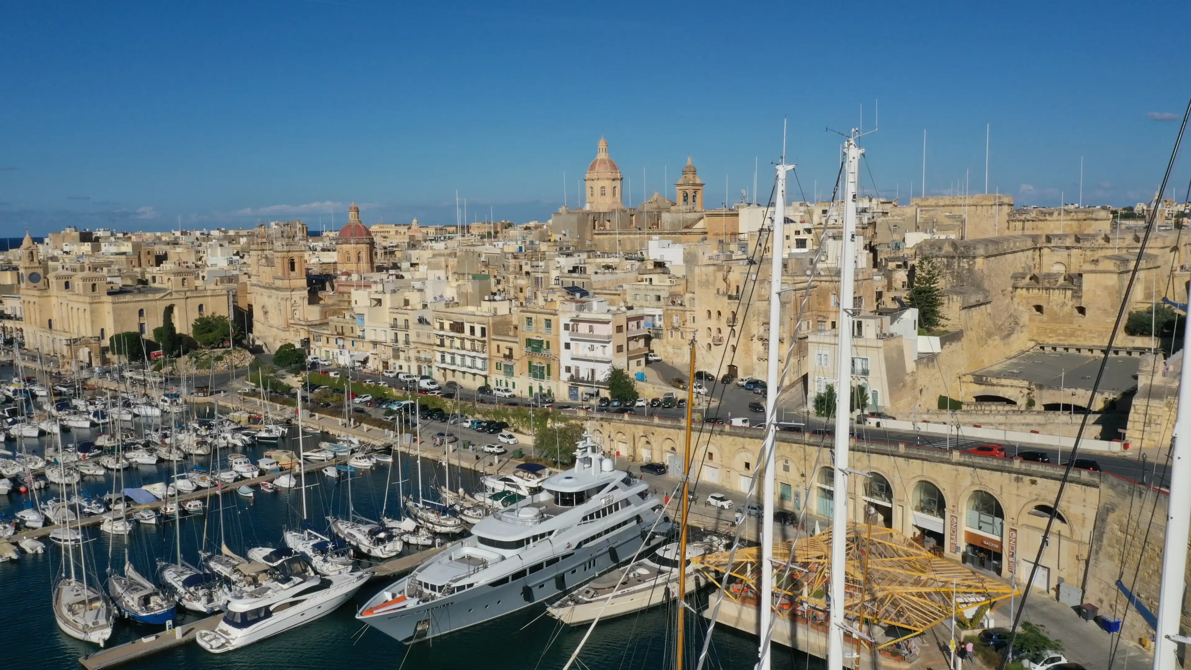 Aerial view of sailboats moored in harbour Senglea, Birgu, Bormla / Cospicua, Valletta, Malta. Ancient architecture of old town: christian orthodox churches, cathedrals, basilicas. Sunny summer travel