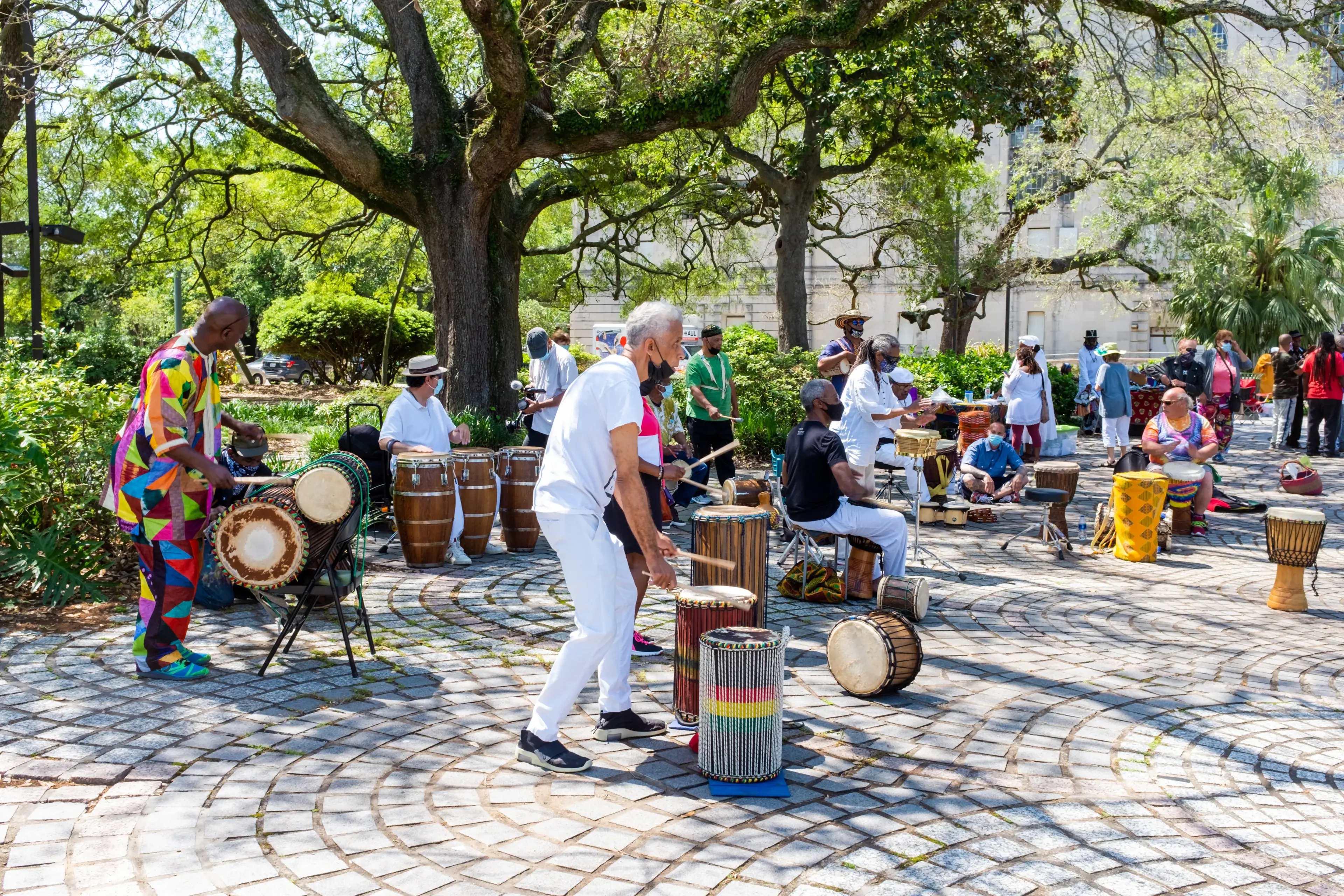 NEW ORLEANS, LA, USA - APRIL 11, 2021: Percussionists, with Luther Gray in foreground, perform in Congo Square to celebrate the life of Alfred "Uganda" Roberts NEW ORLEANS, LA, USA - APRIL 11, 2021: Percussionists, with Luther Gray in foreground, perform in Congo Square to celebrate the life of Alfred "Uganda" Roberts