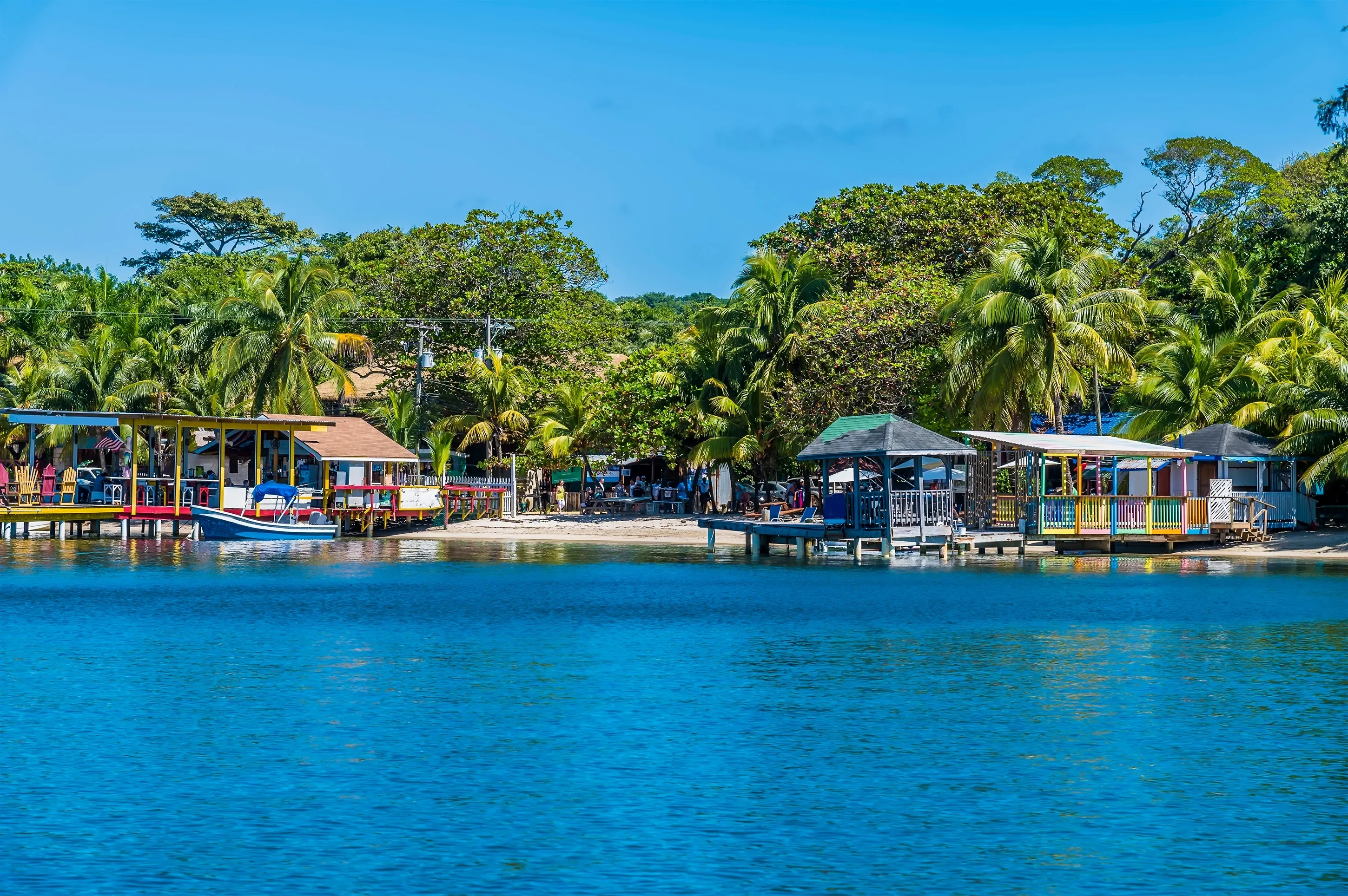 A view from a boat along the shore at West Bay on Roatan Island on a sunny day