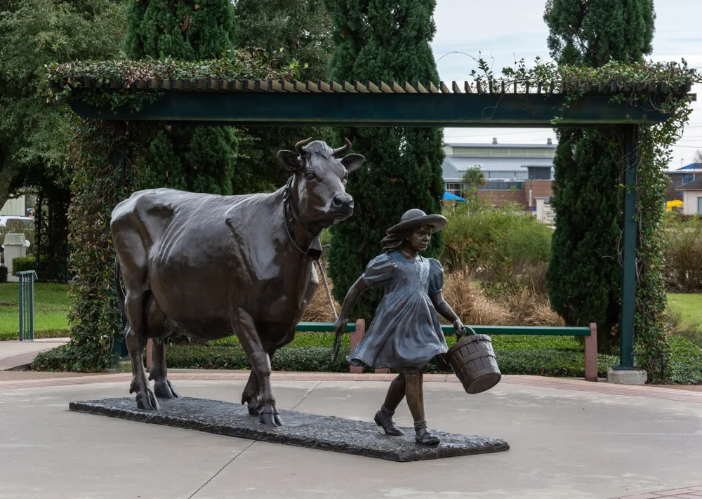 Brenham, Texas, United States of America - December 27, 2016. Monument depicting a girl with a cow in front of the Blue Bell Creameries factory in Brenham, TX.