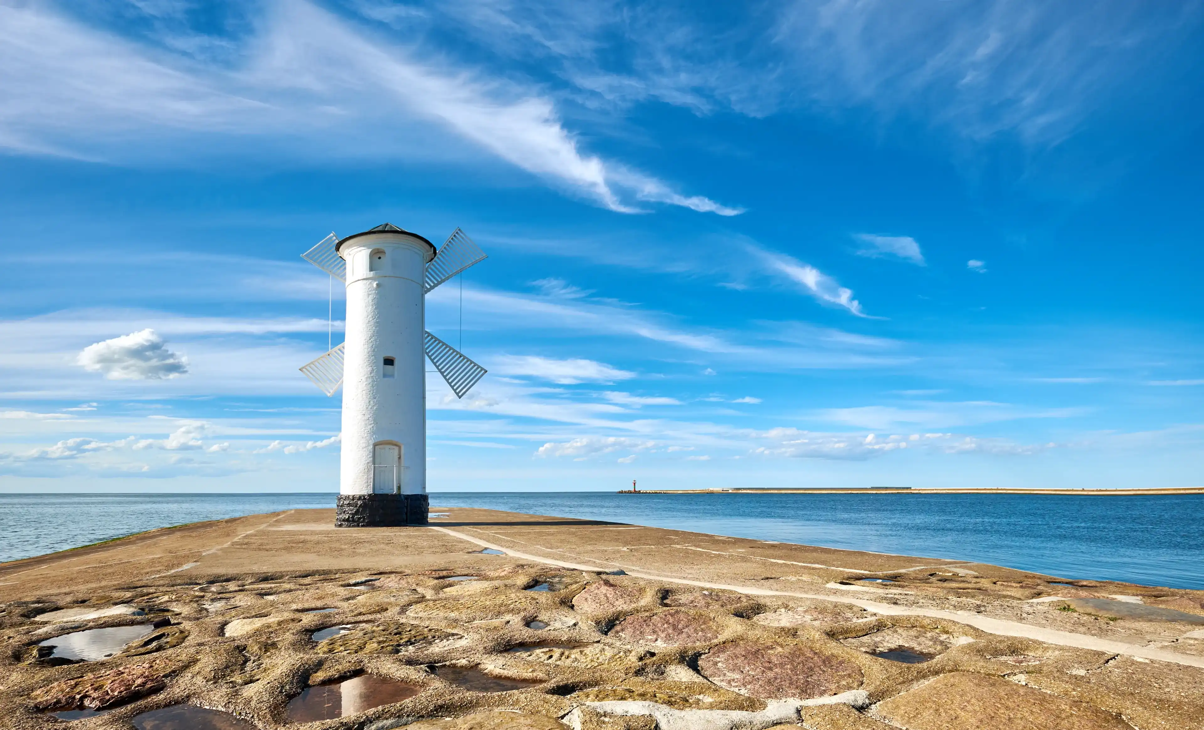 Panoramic image of seawall and retro windmill lighthouse in Swinoujscie, a port in Poland on the Baltic Sea. Panoramic image of seawall and retro windmill lighthouse in Swinoujscie, a port in Poland on the Baltic Sea.
