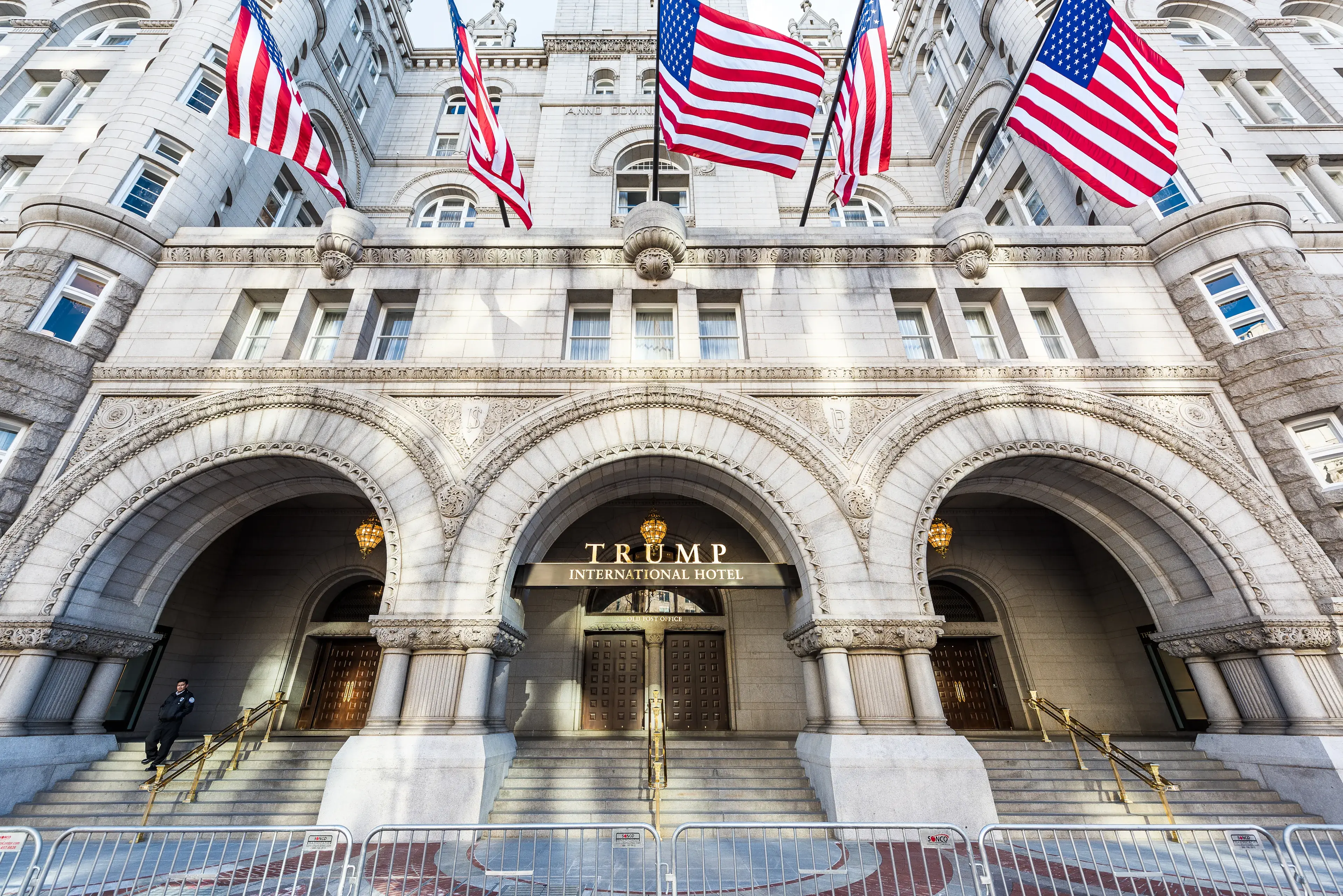 Washington DC, USA - January 28, 2017: Trump International Hotel and the Old Post Office Tower entrance with american flags Washington DC, USA - January 28, 2017: Trump International Hotel and the Old Post Office Tower entrance with american flags