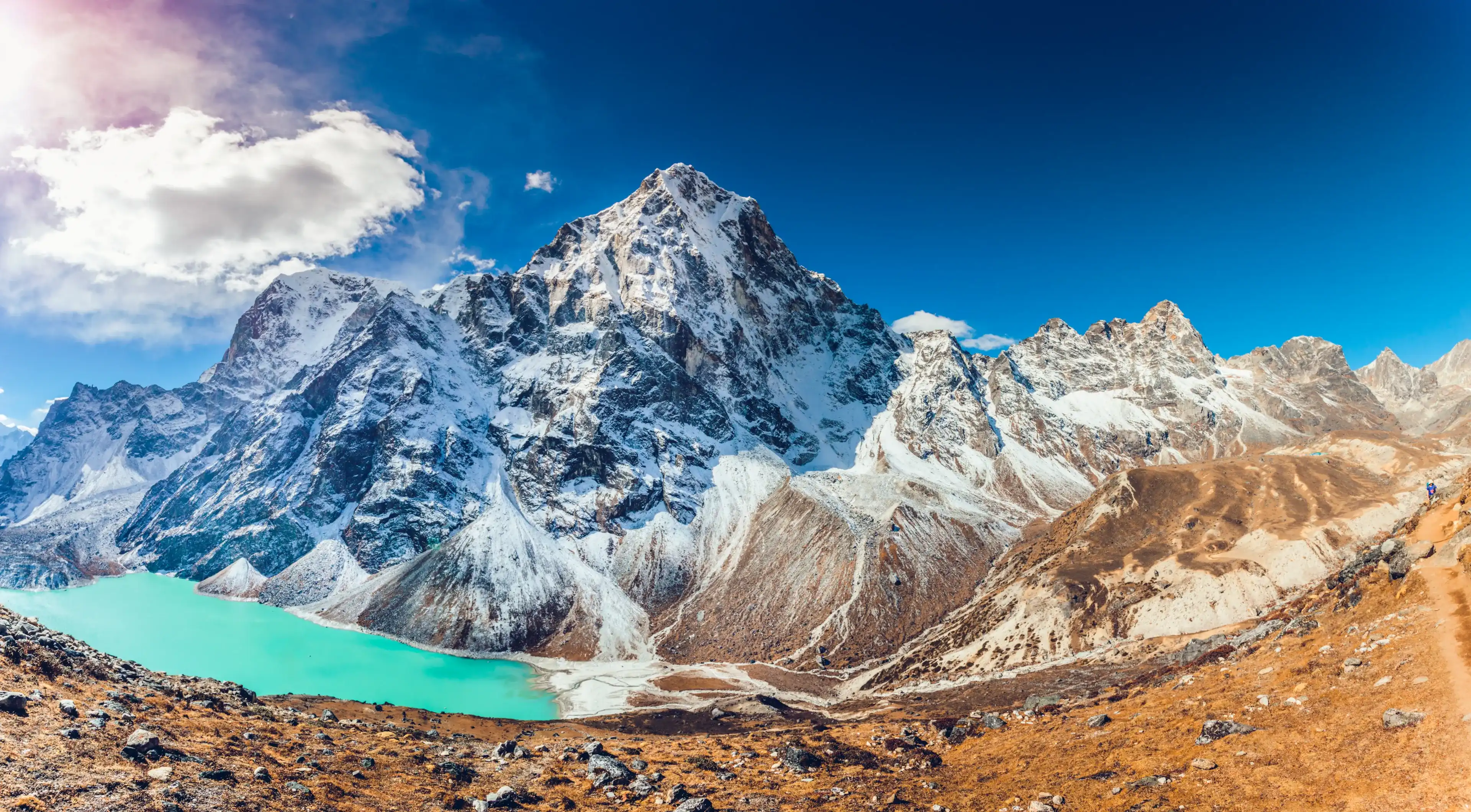 Valley of Himalayan mountains with mountain lake on track to Everest base camp. High mountains with snow-capped peaks. Khumbu valley, Sagarmatha national park, Nepal. Beautiful mountain landscape.