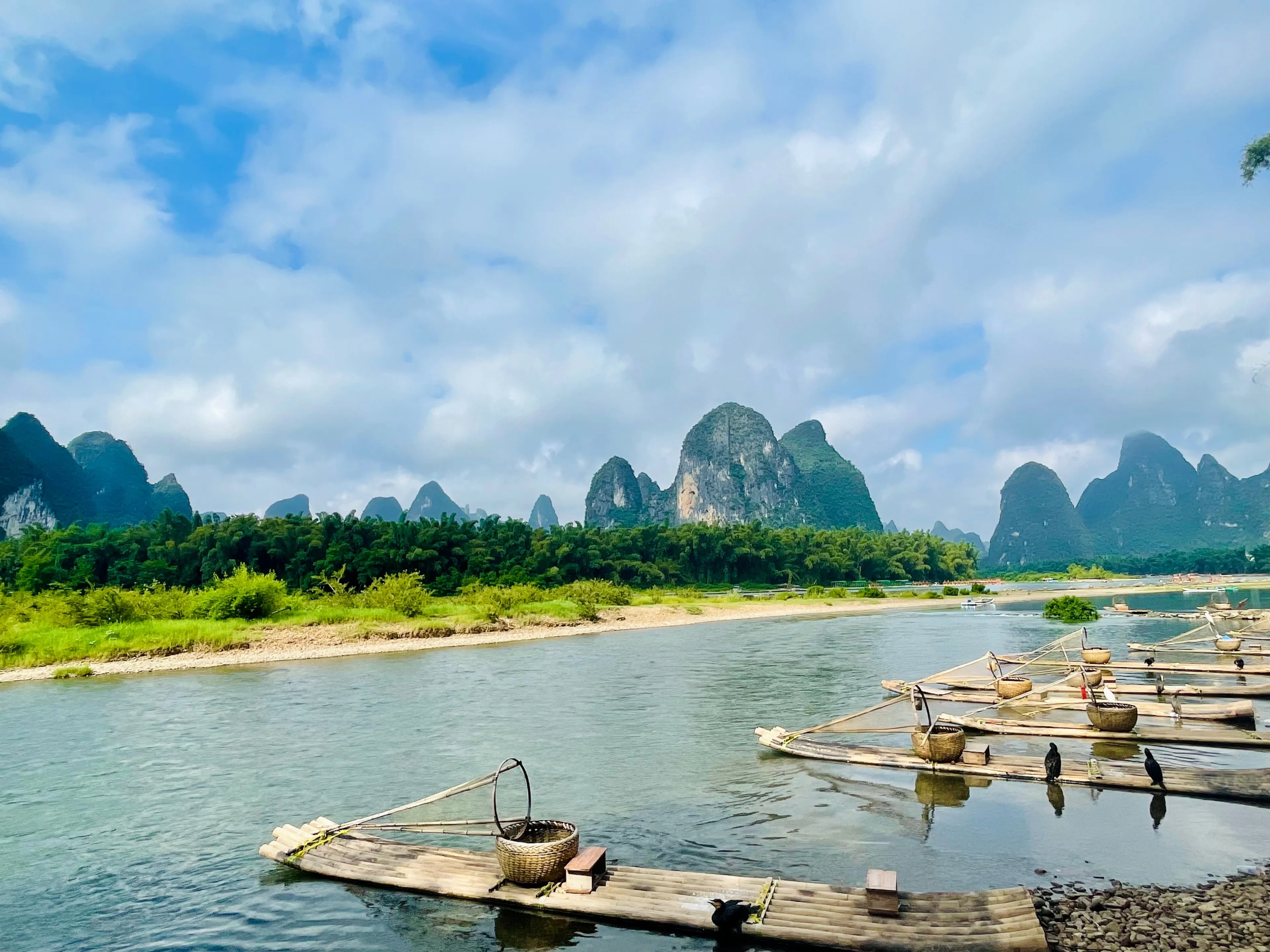 Traditional wooden boats on a tranquil river surrounded by karst mountains. Yangshuo, China