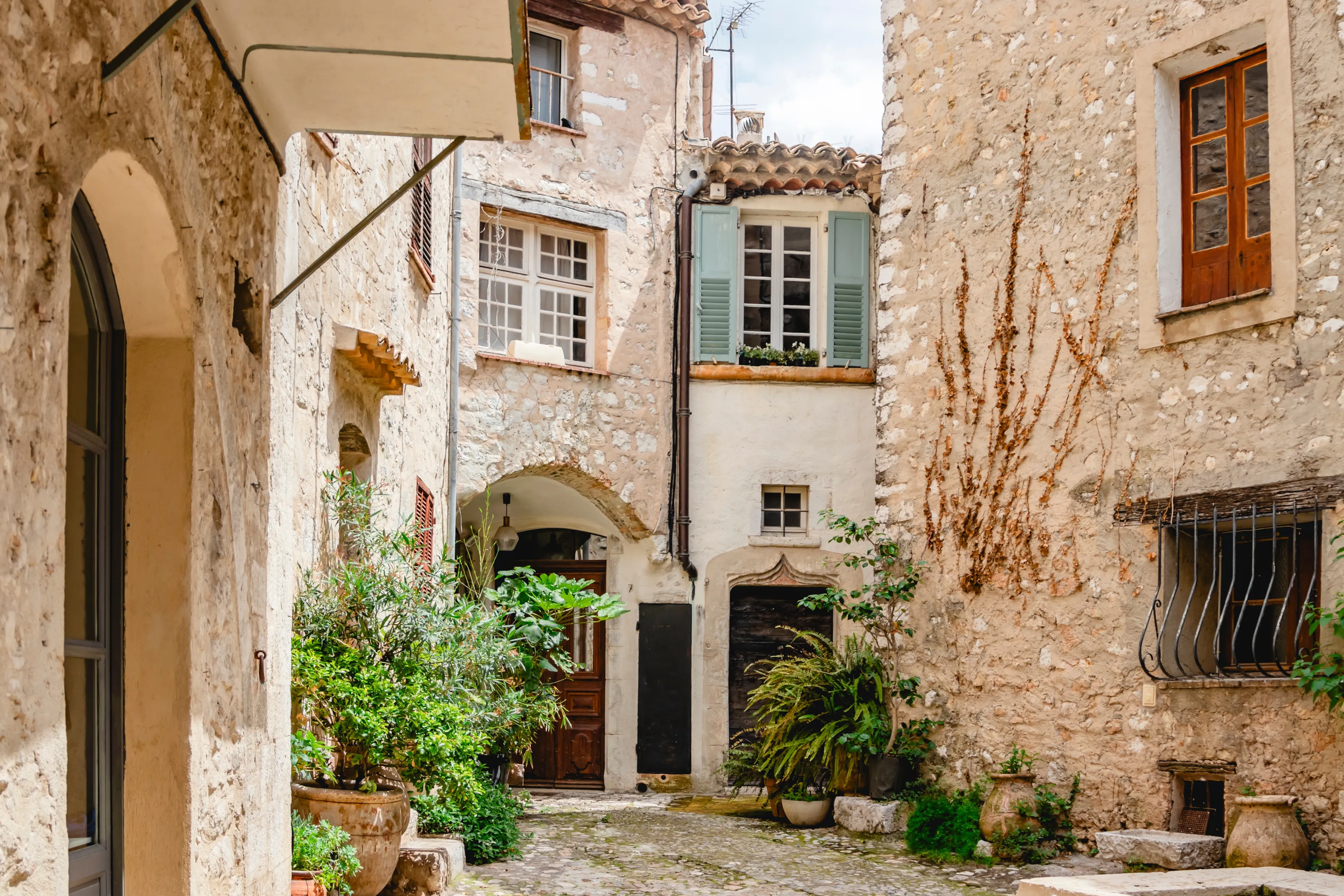 A serene and charming medieval stone alleyway in a picturesque European village decorated with lush plants. Saint Paul de Vence. France. Provence.