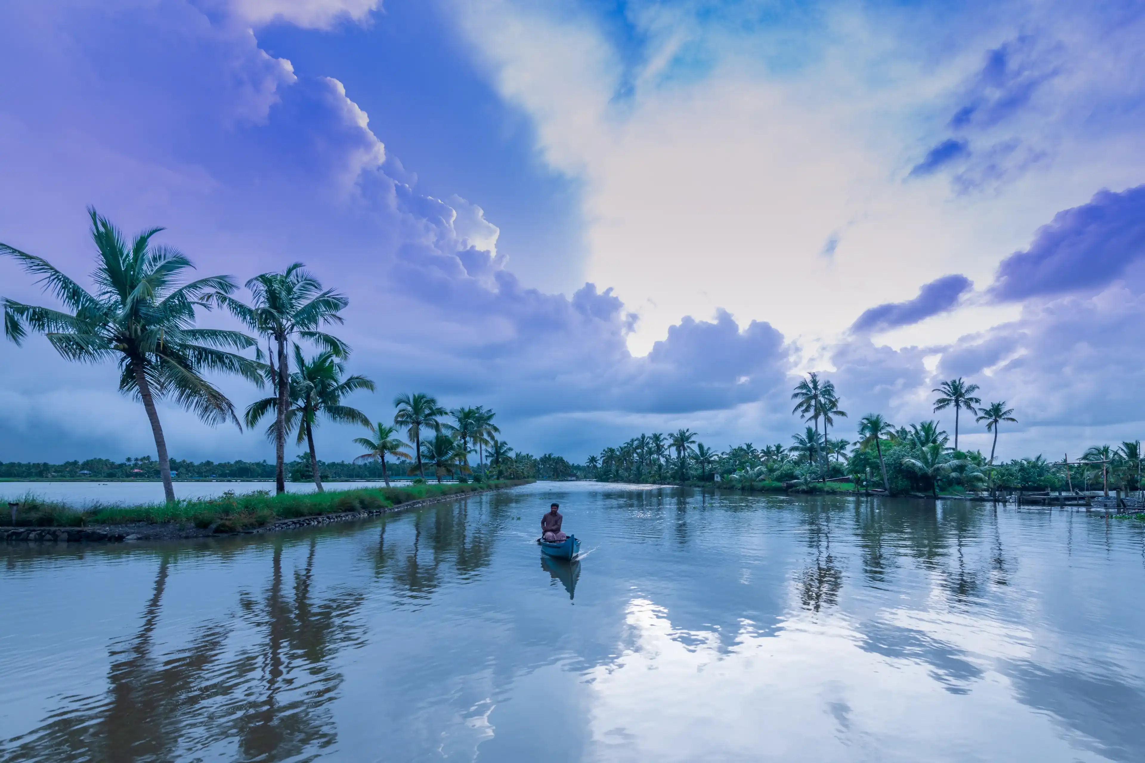 Kadamakkudy, Ernakulam, India - February7, 2020, Morning view of backwaters, coconut trees and fisher man in Kerala boat on a Cloudy day Kadamakkudy, Ernakulam, India - February7, 2020, Morning view of backwaters, coconut trees and fisher man in Kerala boat on a Cloudy day