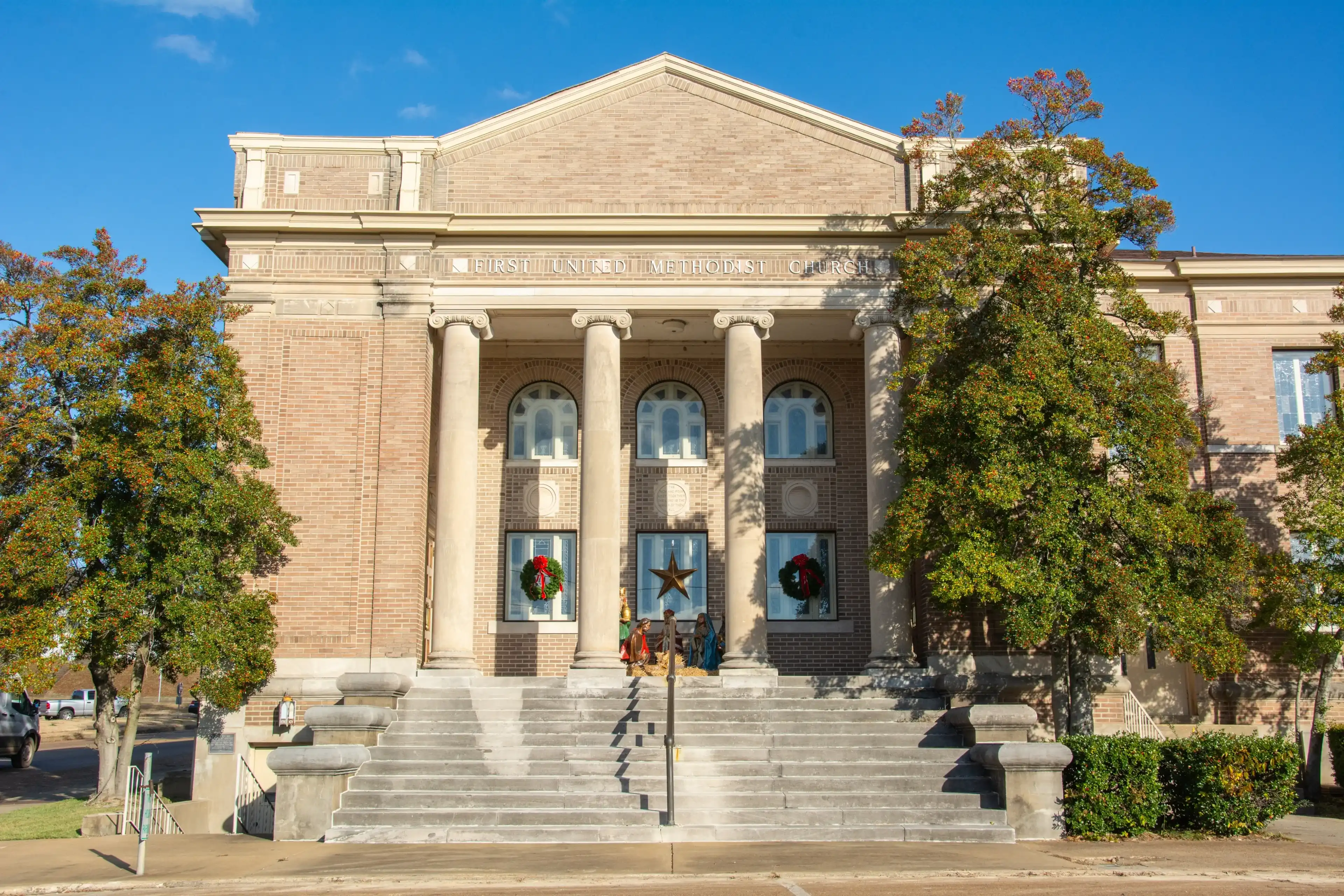 Greek-style temple front view of the Classical Revival style historic First United Methodist Church and community center on Izard Street in Forrest City, Arkansas, USA Greek-style temple front view of the Classical Revival style historic First United Methodist Church and community center on Izard Street in Forrest City, Arkansas, USA