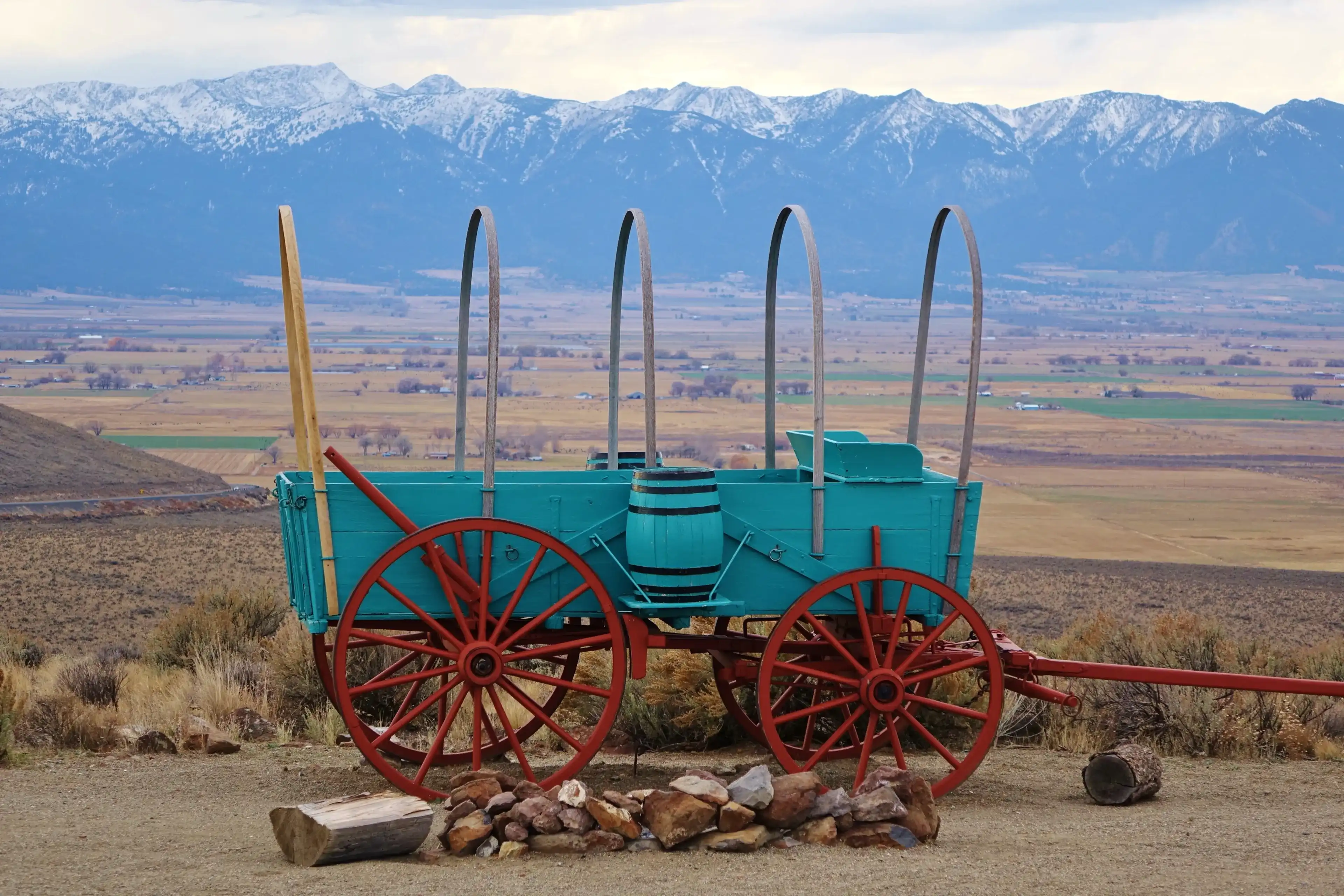 Oregon Trail Interpretive Center near Baker City, OR features several old wagons and beautiful views. This uncovered wagon sits above a sagebrush filled valley with the Blue Mountains in the distance. Oregon Trail Interpretive Center near Baker City, OR features several old wagons and beautiful views. This uncovered wagon sits above a sagebrush filled valley with the Blue Mountains in the distance.