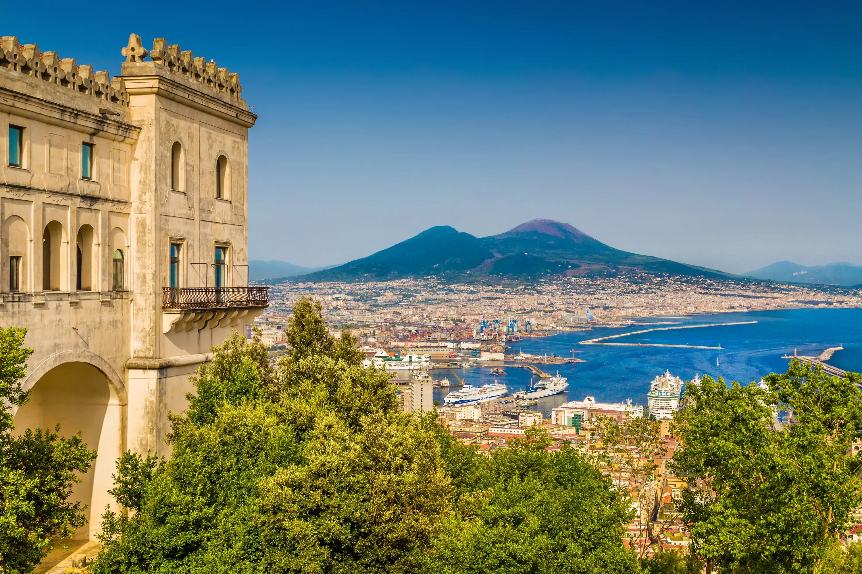 Scenic picture-postcard view of the city of Naples (Napoli) with famous Mount Vesuvius in the background from Certosa di San Martino monastery, Campania, Italy Scenic picture-postcard view of the city of Naples (Napoli) with famous Mount Vesuvius in the background from Certosa di San Martino monastery, Campania, Italy