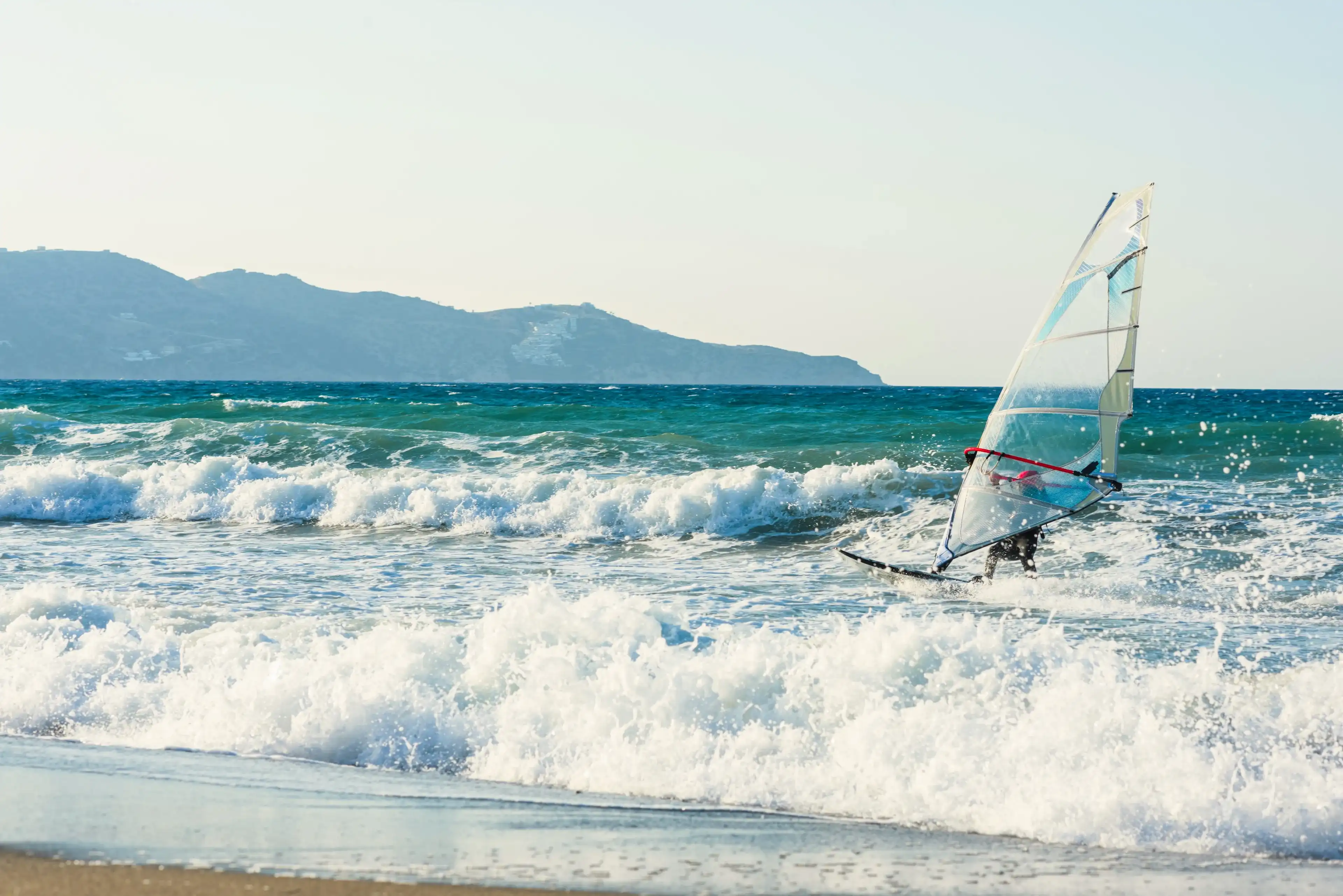 Windsurfers in the sea on Crete on sunset. Windsurfing in Heraklion. Greece Windsurfers in the sea on Crete on sunset. Windsurfing in Heraklion. Greece