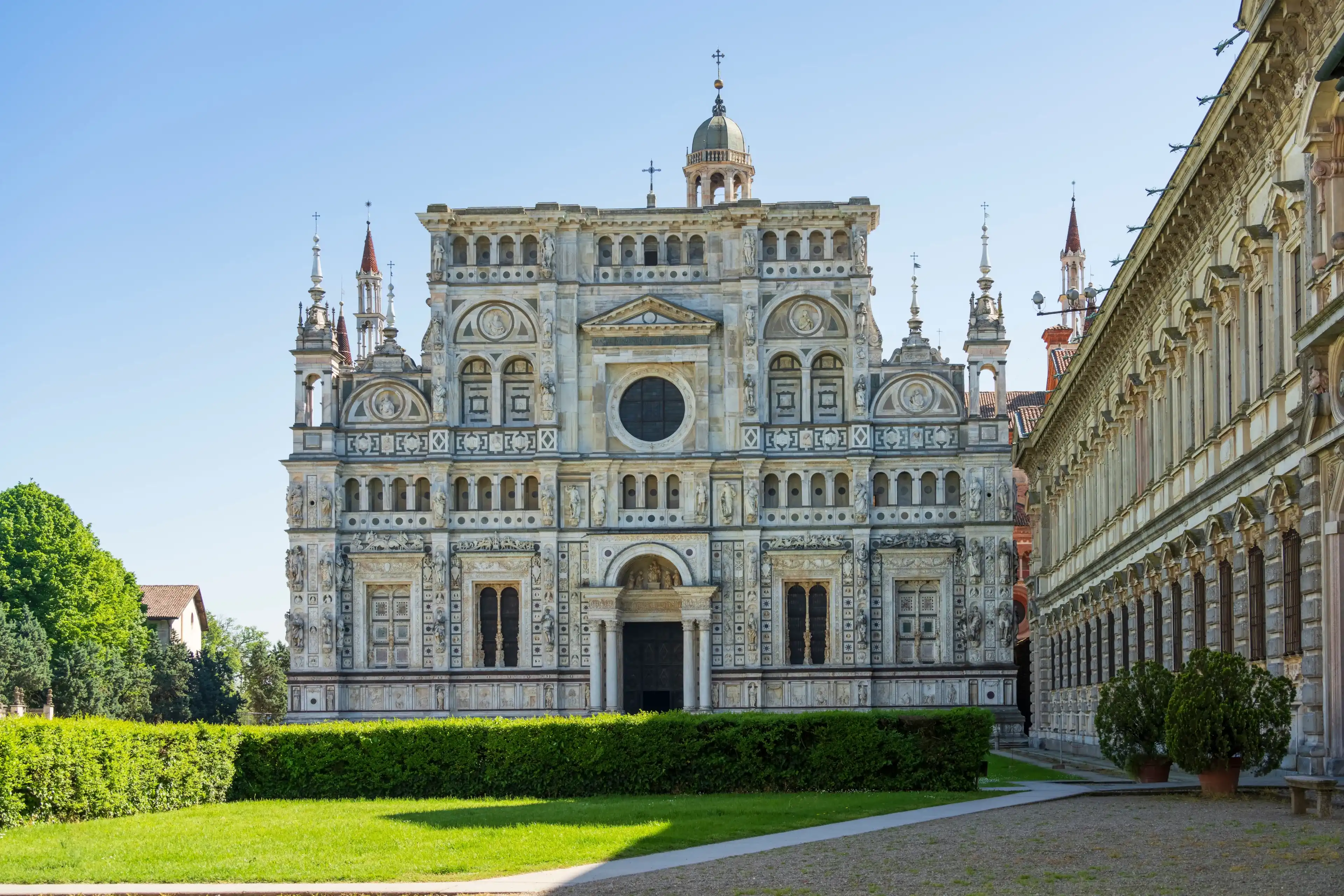 Certosa di Pavia monastery, historical monumental complex that includes a monastery and a sanctuary. green court and a church.The Ducale Palace on the right,Pavia,Italy. Certosa di Pavia monastery, historical monumental complex that includes a monastery and a sanctuary. green court and a church.The Ducale Palace on the right,Pavia,Italy.