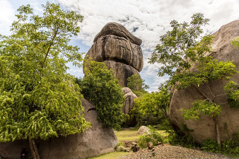 Landscape of Kit Mikayi, an impressive balancing rock formation or tor, about 40 m high, in Seme, Kisumu County, western Kenya, Africa. Visitors include tourists, local Luo tribe & Legio Maria sect. 