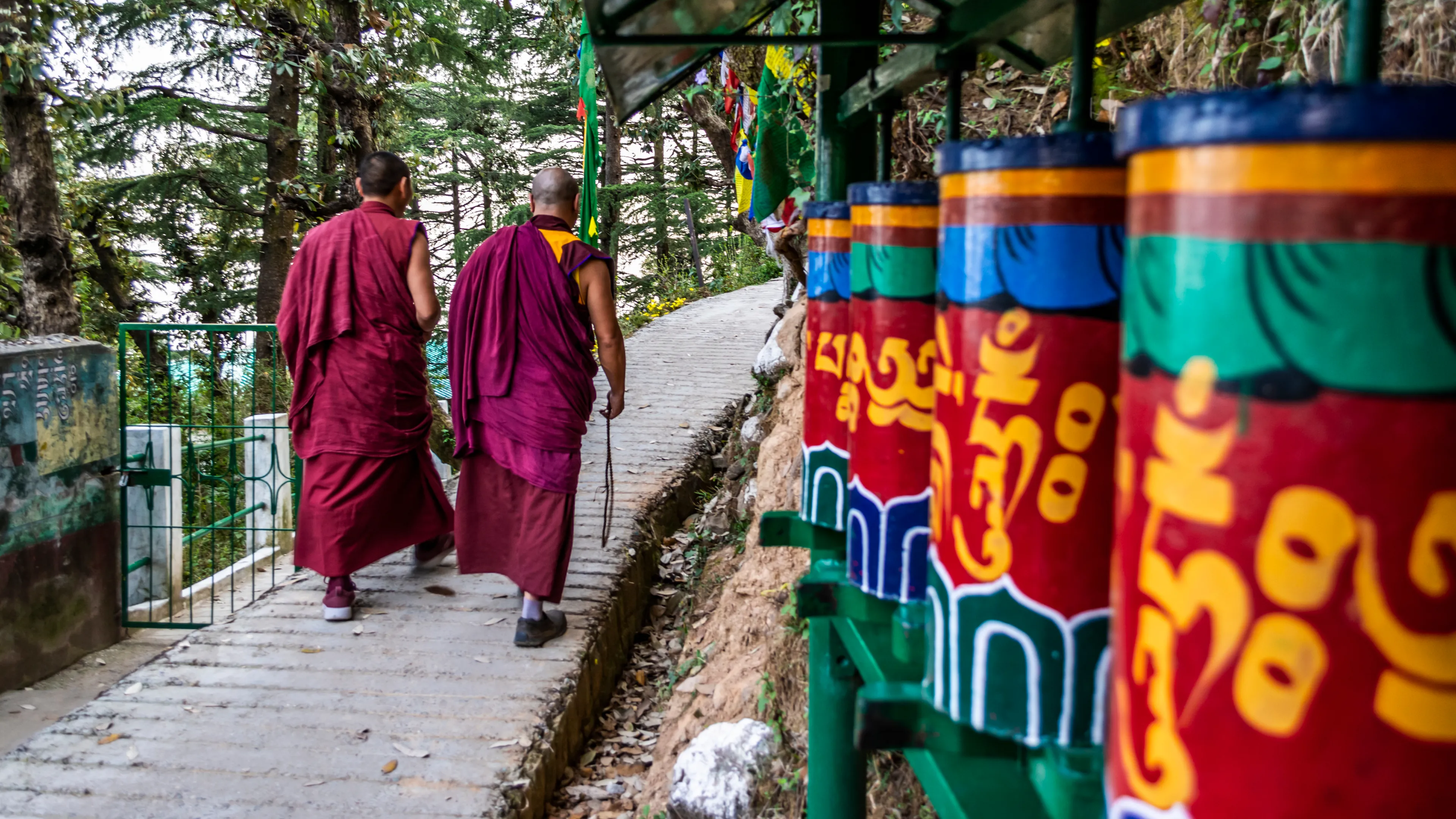Tibetan Monks walking among praying wheels, Dharamsala, India
