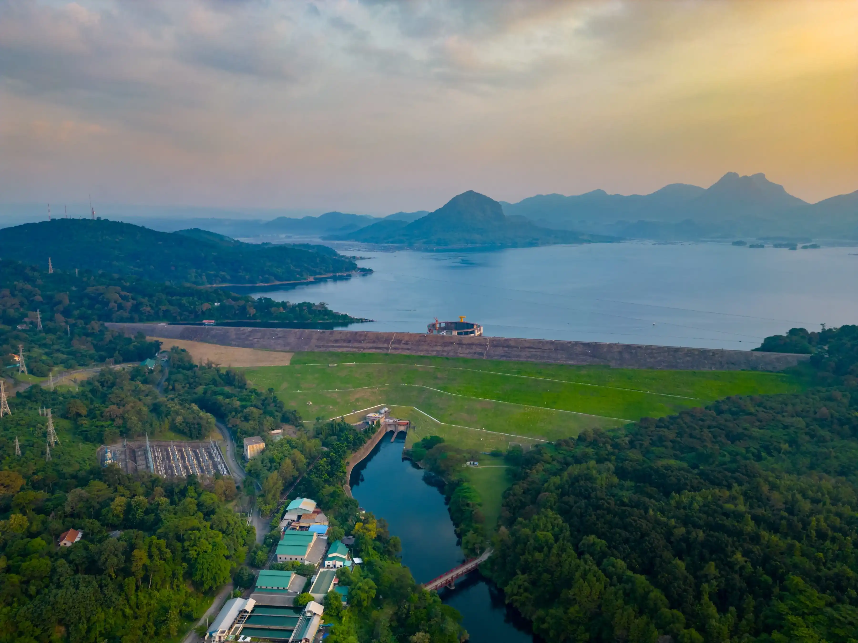 Drone View of Jatiluhur Dam and Reservoir in Purwakarta, Indonesia – Scenic Lake, Green Hills, Hydropower Station, and Mountains at Sunset Drone View of Jatiluhur Dam and Reservoir in Purwakarta, Indonesia – Scenic Lake, Green Hills, Hydropower Station, and Mountains at Sunset
