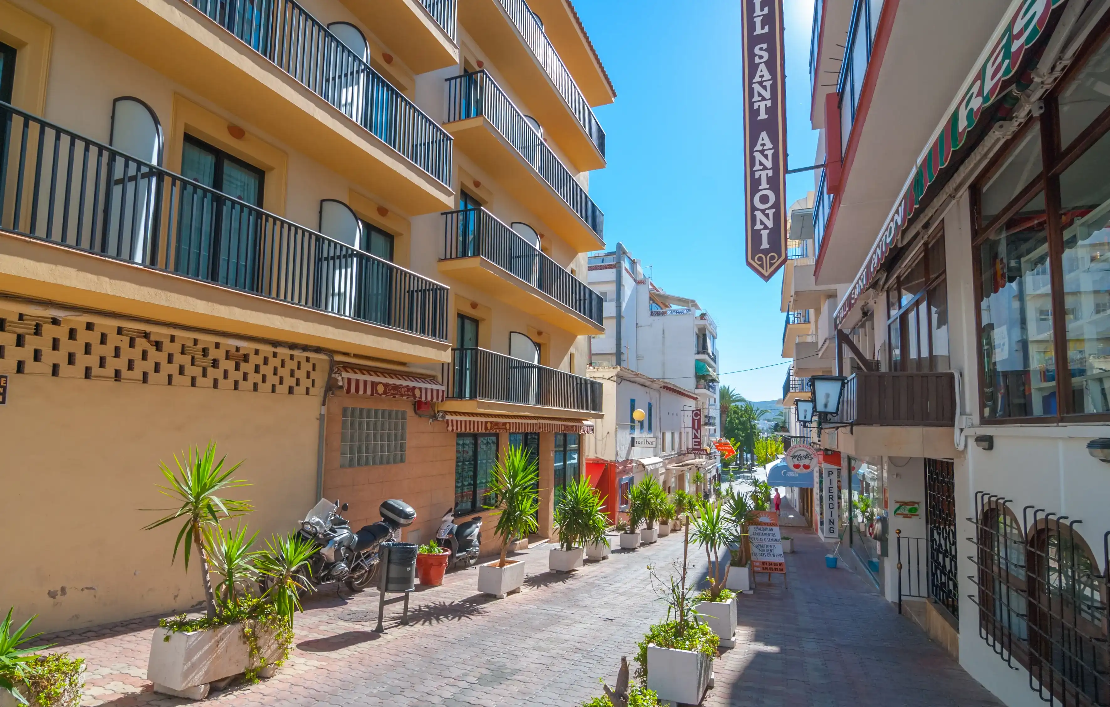 Sant Antoni De Portmany, Ibiza, November 6th, 2013: Tourism in Spain. Bright sunshine on in town of Ibiza in the off-season. Empty & quite colorful street and shops. Sant Antoni De Portmany, Ibiza, November 6th, 2013: Tourism in Spain. Bright sunshine on in town of Ibiza in the off-season. Empty & quite colorful street and shops.