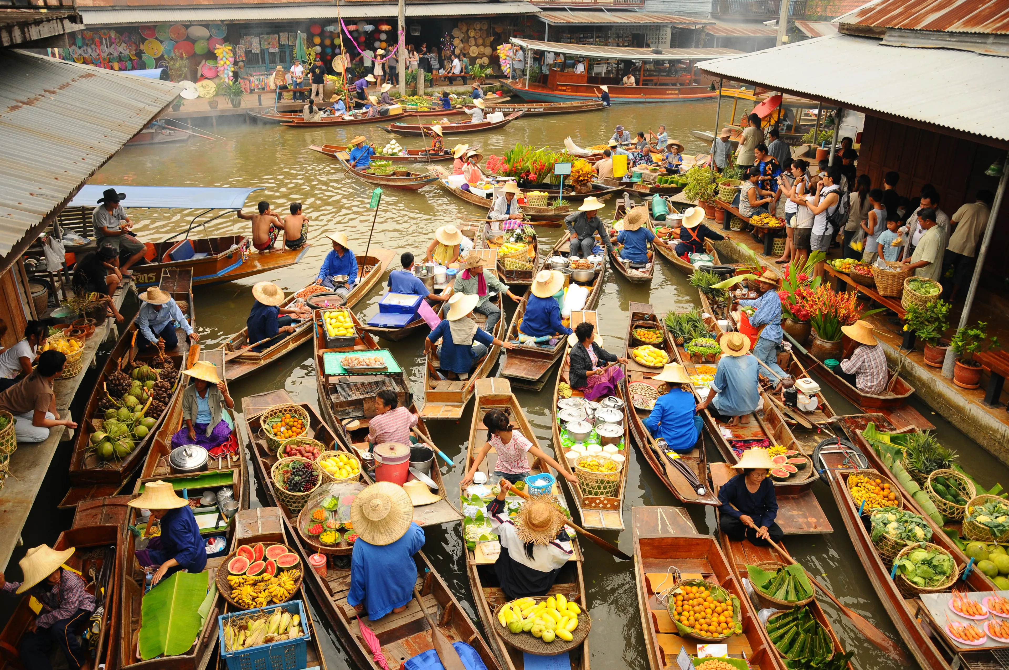 BANGKOK –  APRIL 13: Wooden boats busy ferrying people at Amphawa floating market on April 13, 2011 in Bangkok. A traditional popular method of buying and selling still practiced in Amphawa canals of Thailand.