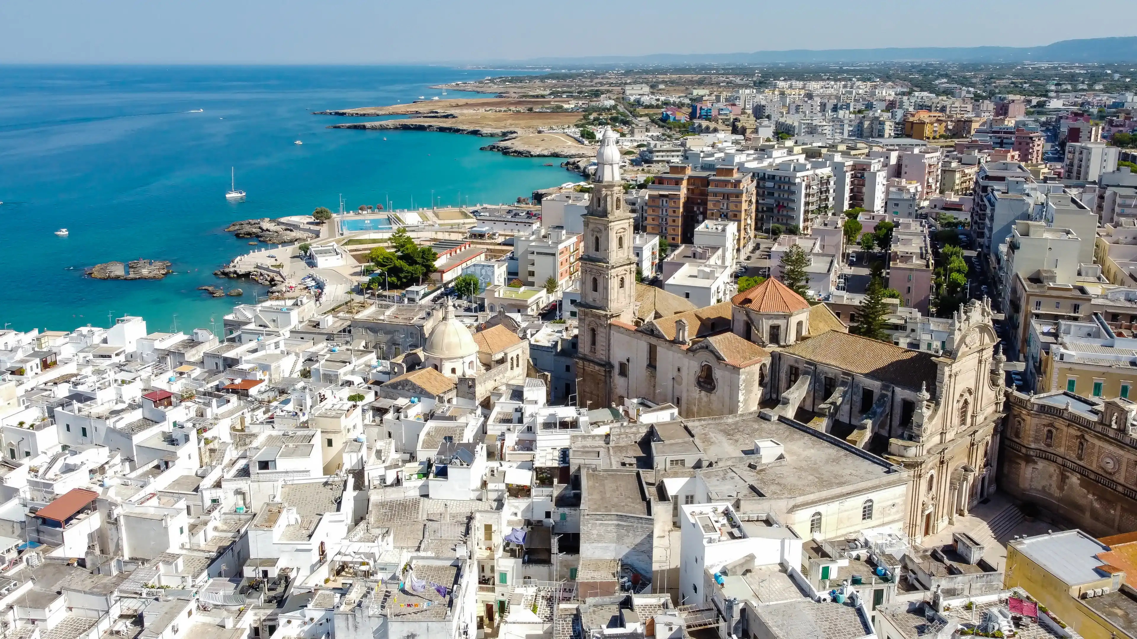 Aerial view of Monopoli in Apulia, south of Italy - Monopoli Cathedral aka Basilica of the Madonna della Madia from above, in front of the Adriatic Sea