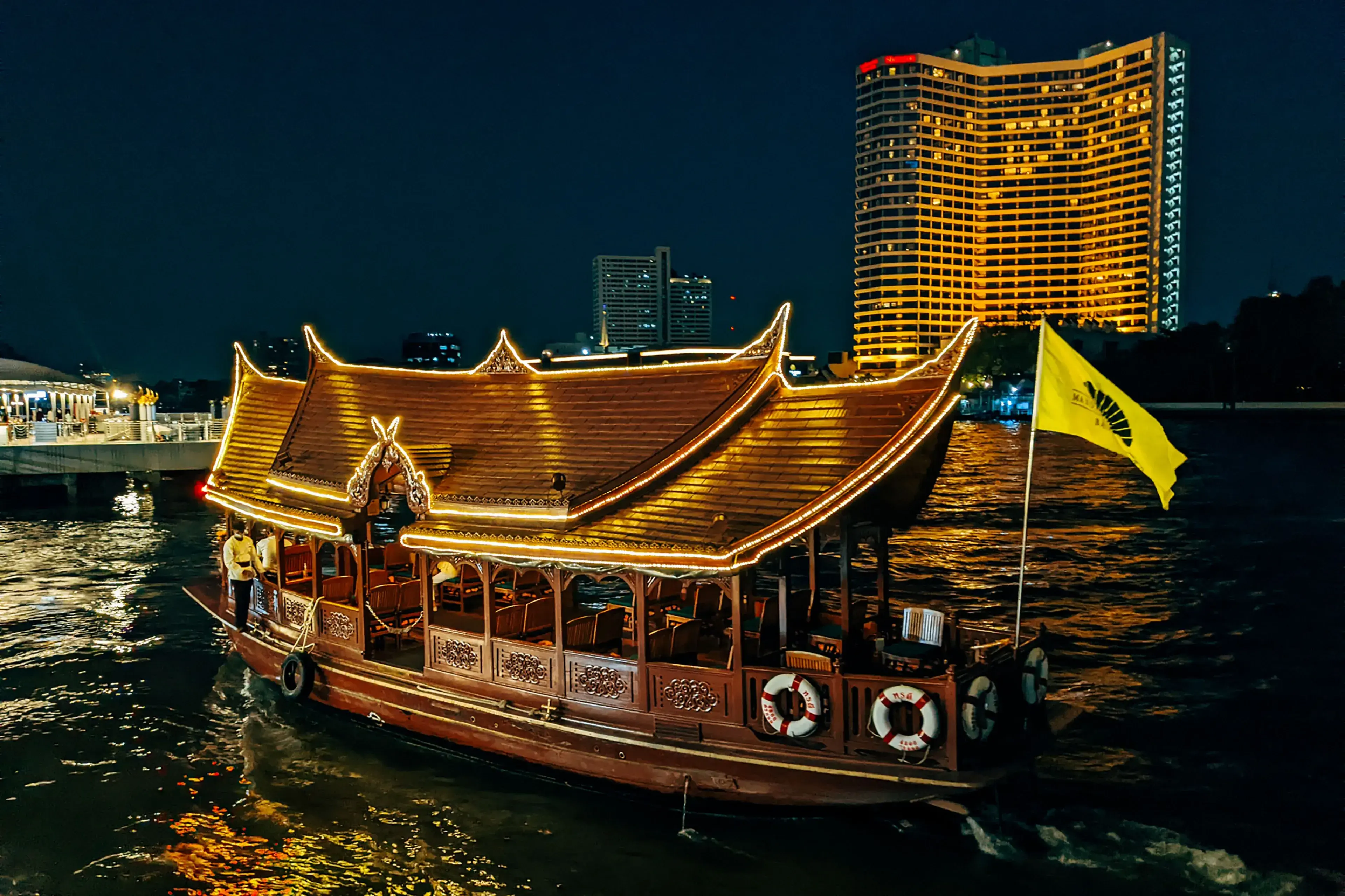 Traditional wooden Thai boat with lights on a river in Bangkok, Thailand at night Traditional wooden Thai boat with lights on a river in Bangkok, Thailand at night
