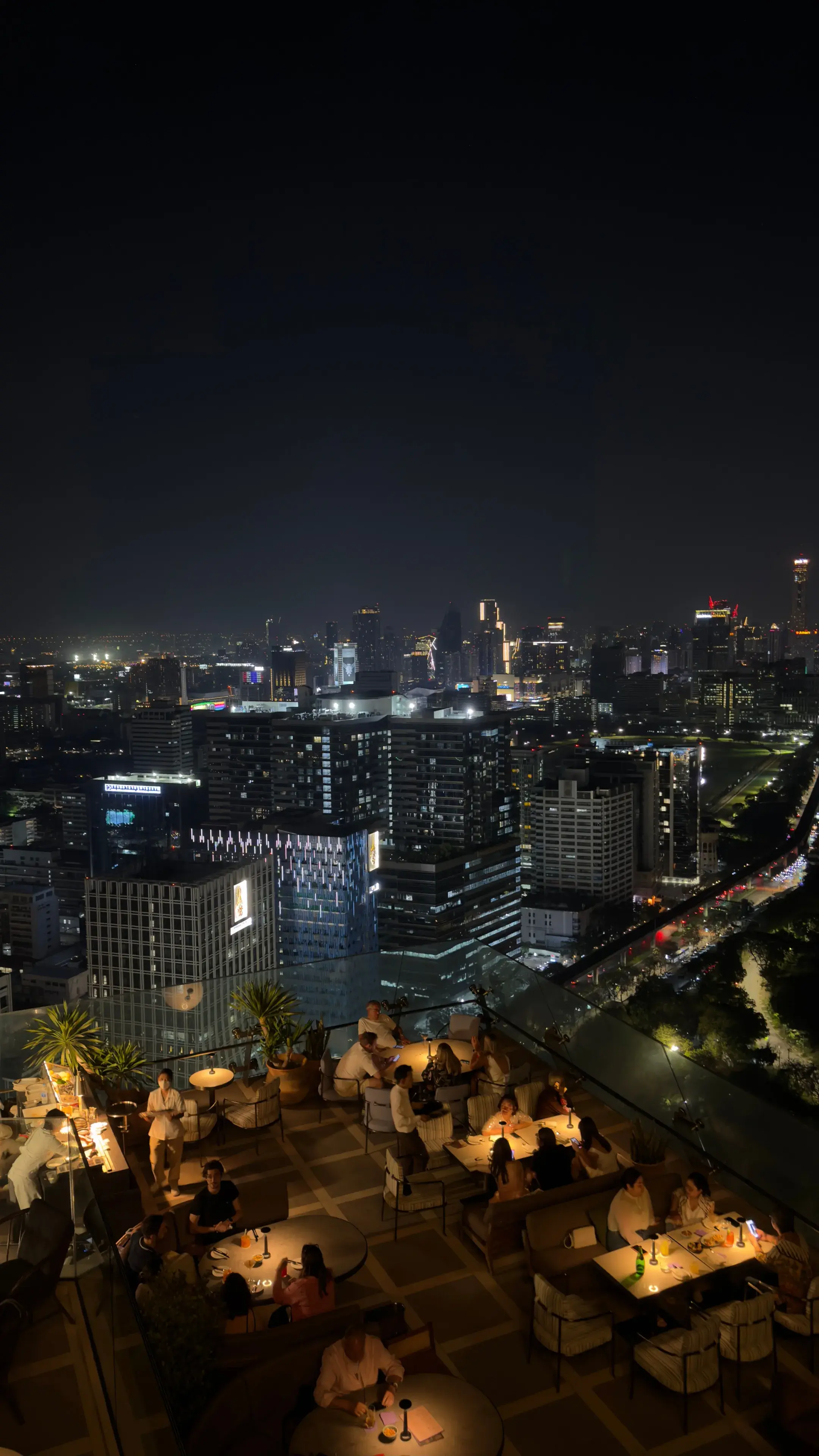 Stunning view of Bangkok skyline and rooftop bar ambiance at night from high vantage point Stunning view of Bangkok skyline and rooftop bar ambiance at night from high vantage point