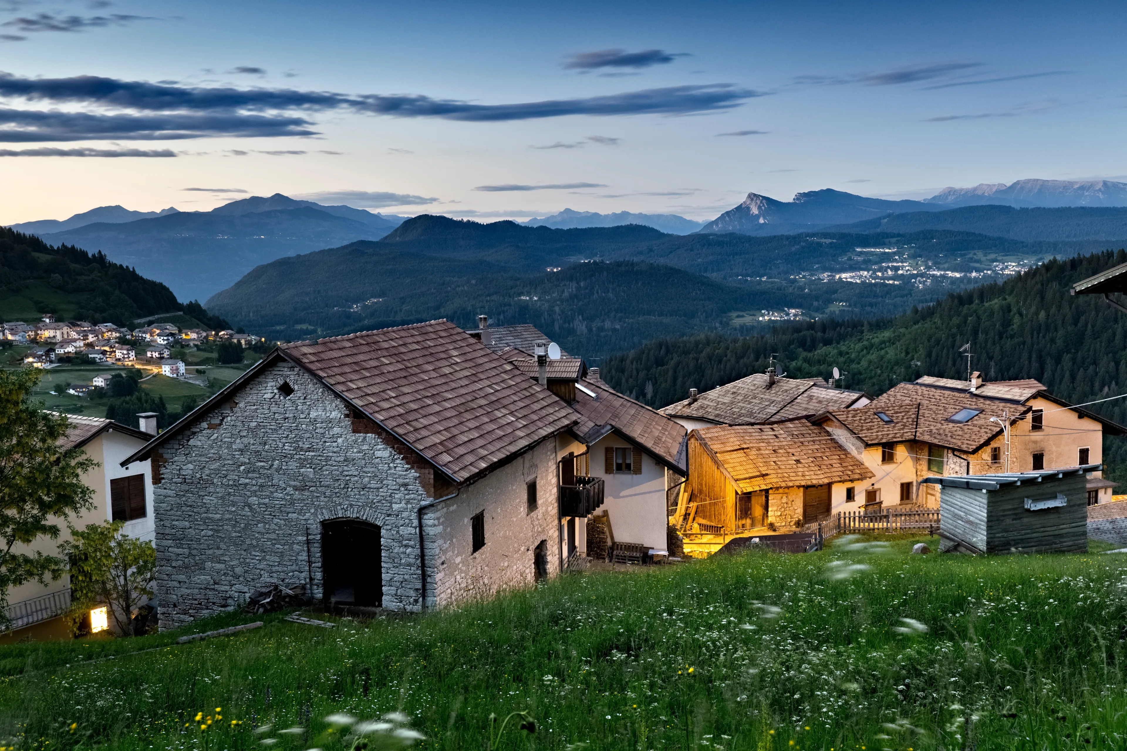 Dusk at the alpine village of Perpruneri. In the background the Lavarone plateau. Folgaria, Alpe Cimbra, Trentino, Italy.