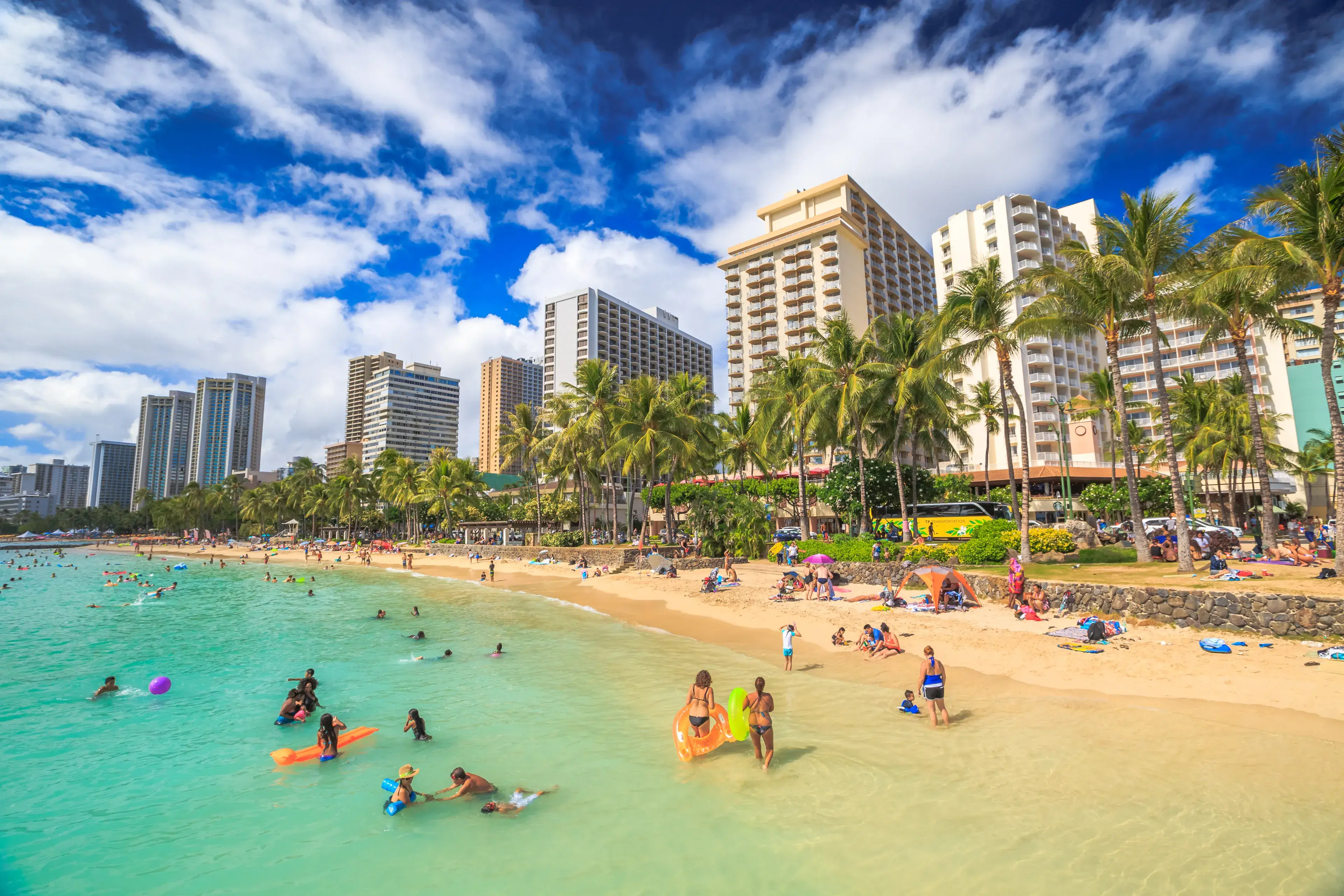 Waikiki, Oahu, HI - August 27, 2016: summertime in crowded Prince Kuhio Beach also called The Ponds because a concrete wall makes the water calm and sicura. Kuhio Beach is a section of Waikiki Beach. Waikiki, Oahu, HI - August 27, 2016: summertime in crowded Prince Kuhio Beach also called The Ponds because a concrete wall makes the water calm and sicura. Kuhio Beach is a section of Waikiki Beach.