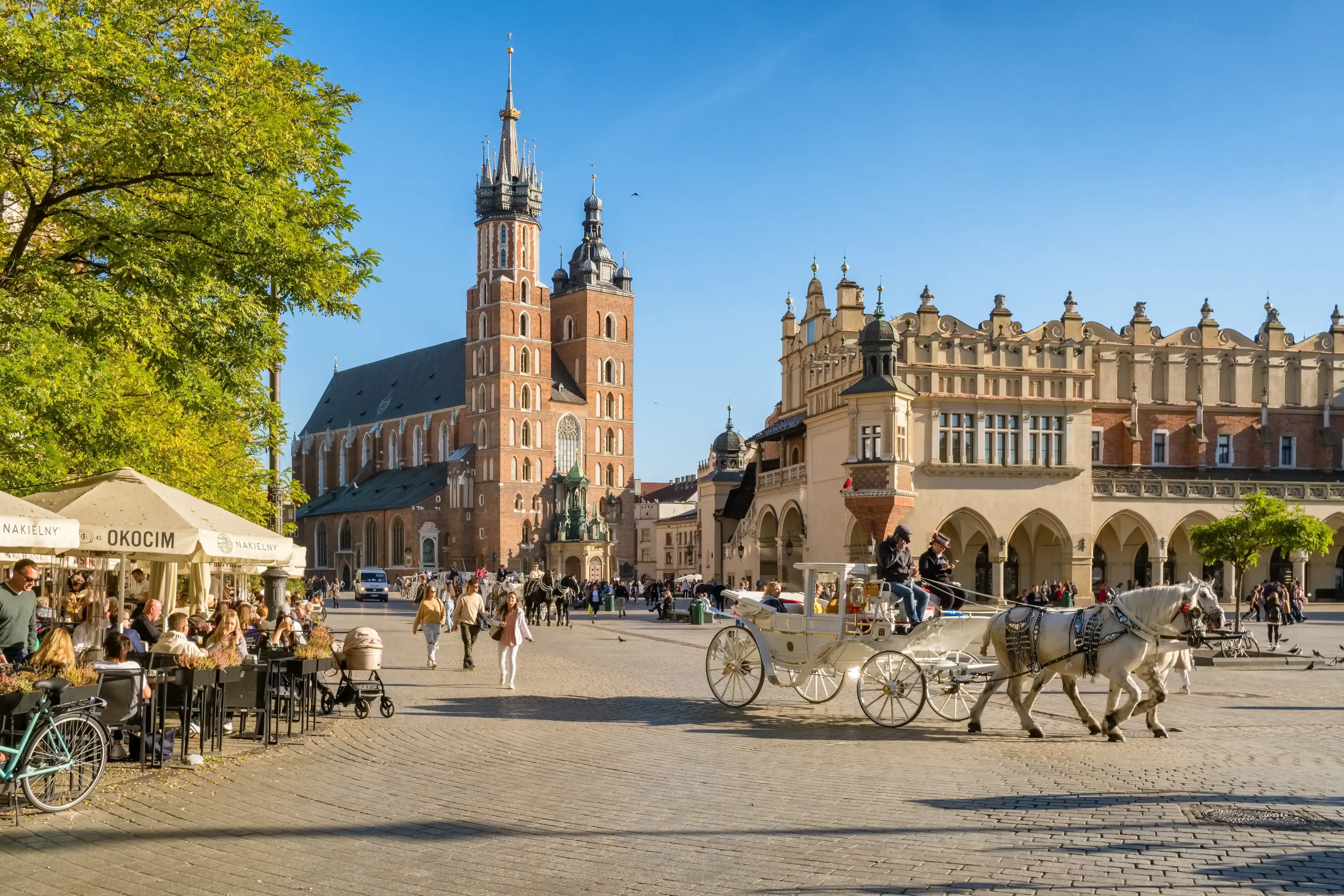 Krakow, Poland - October 27, 2022: Krakow cloth hall and Saint Mary's Basilica on the main market square at sunny day in Cracow, Poland.