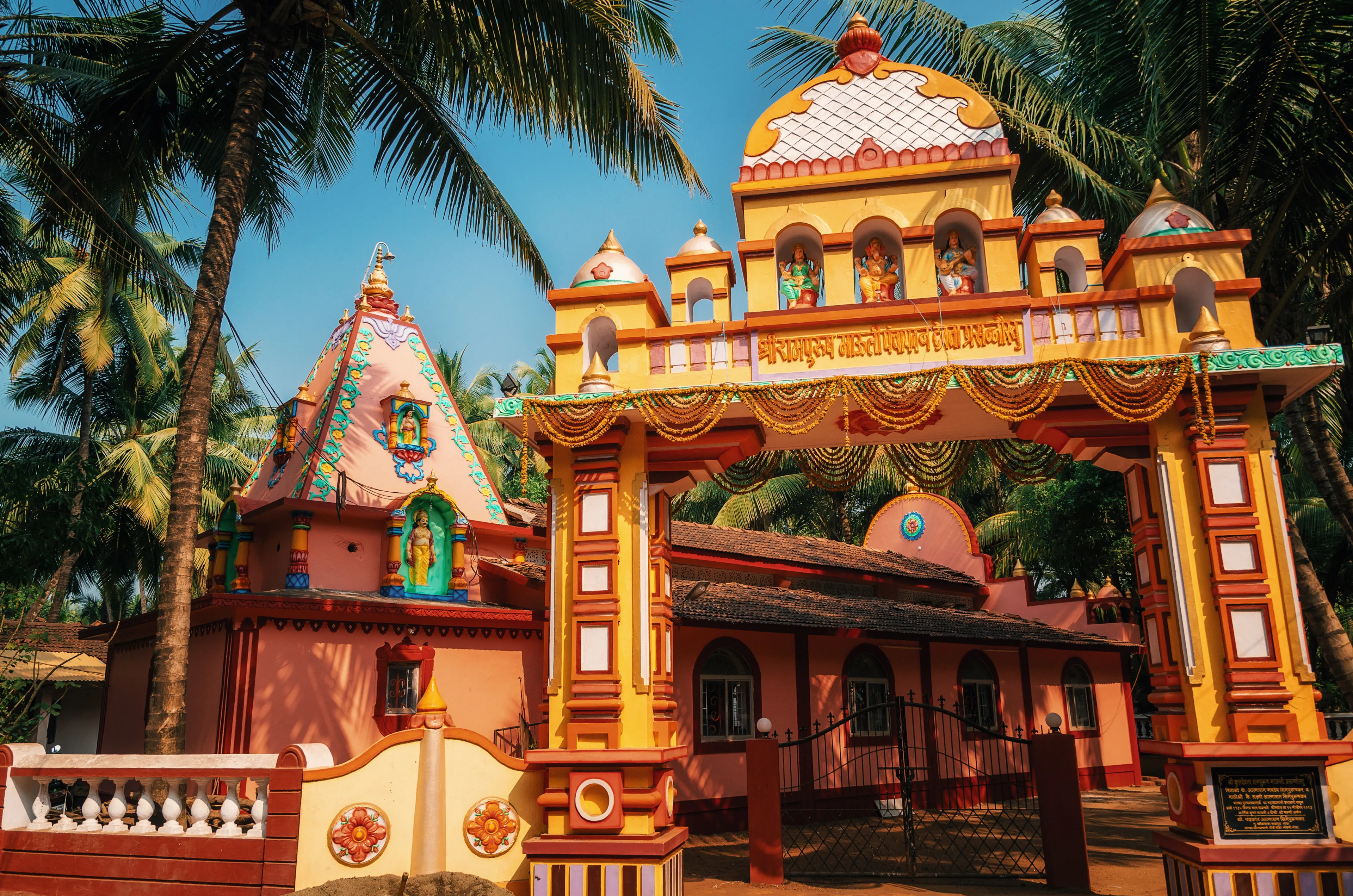 Vivid colorful Hindu Temple at Morjim amidst a coconut grove, North Goa, India.