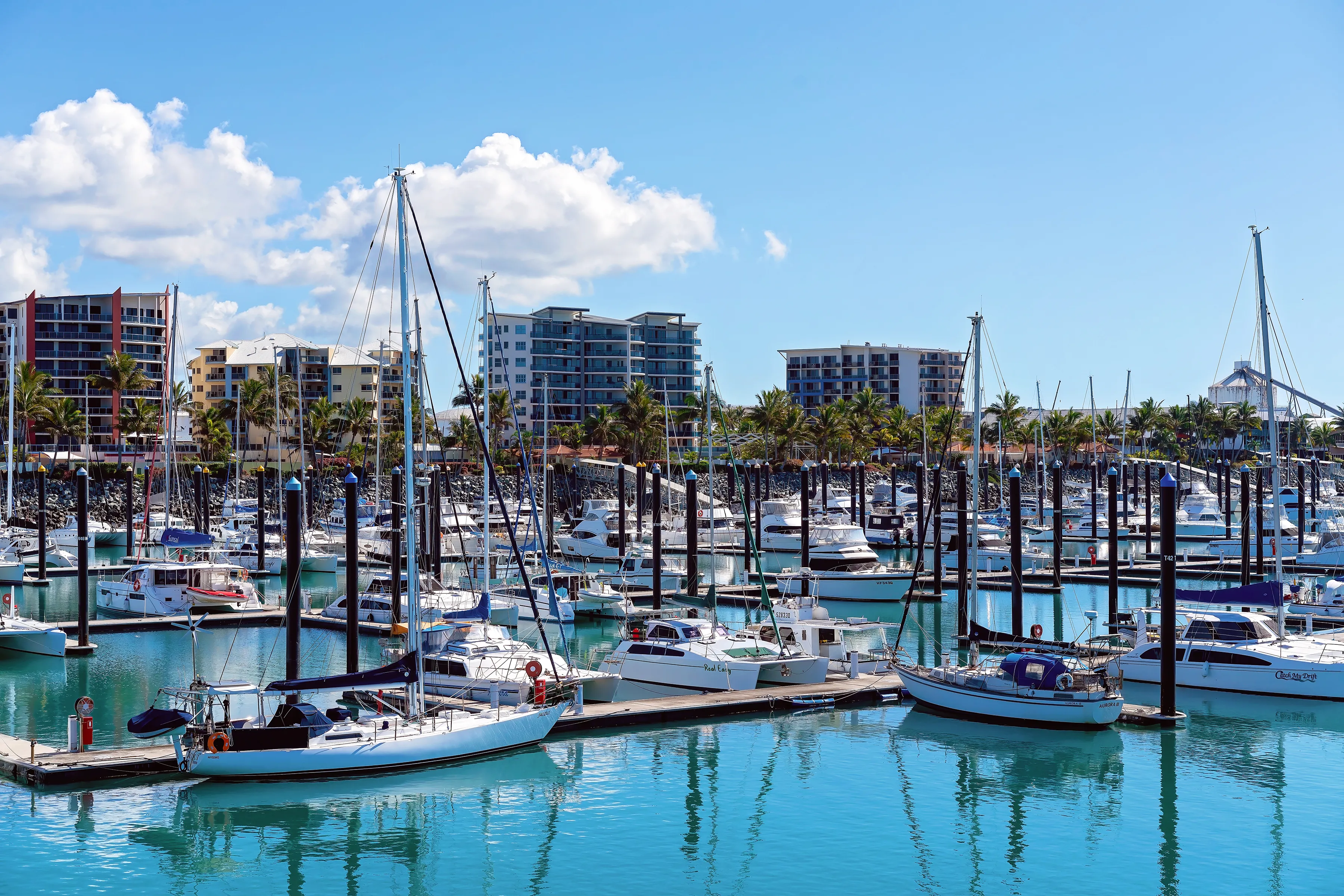 Mackay, Queensland, Australia - June 2020: Luxury boats moored at marina berths in calm blue water