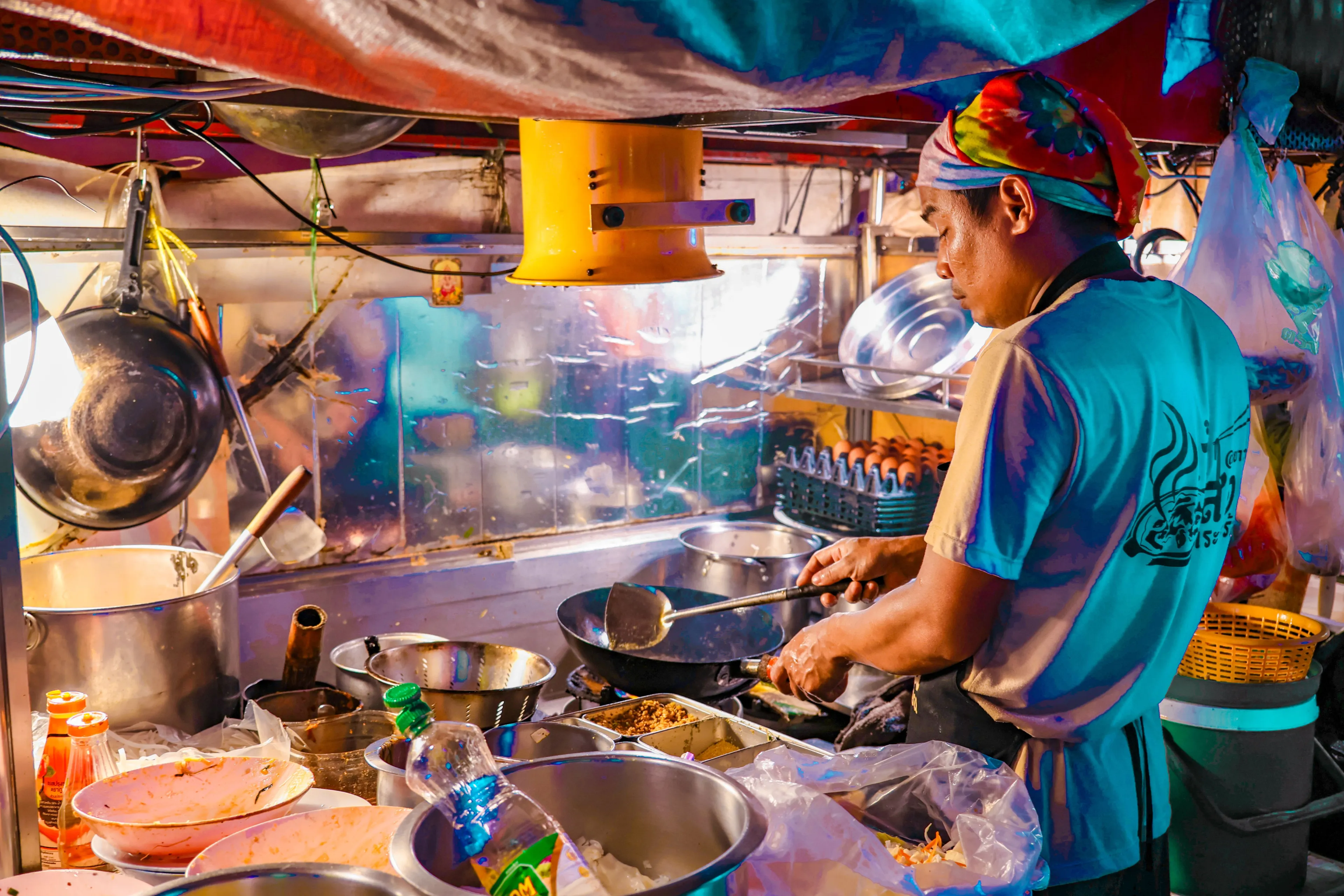 Authentic Thai street food vendor cooking at a vibrant Bangkok night market.