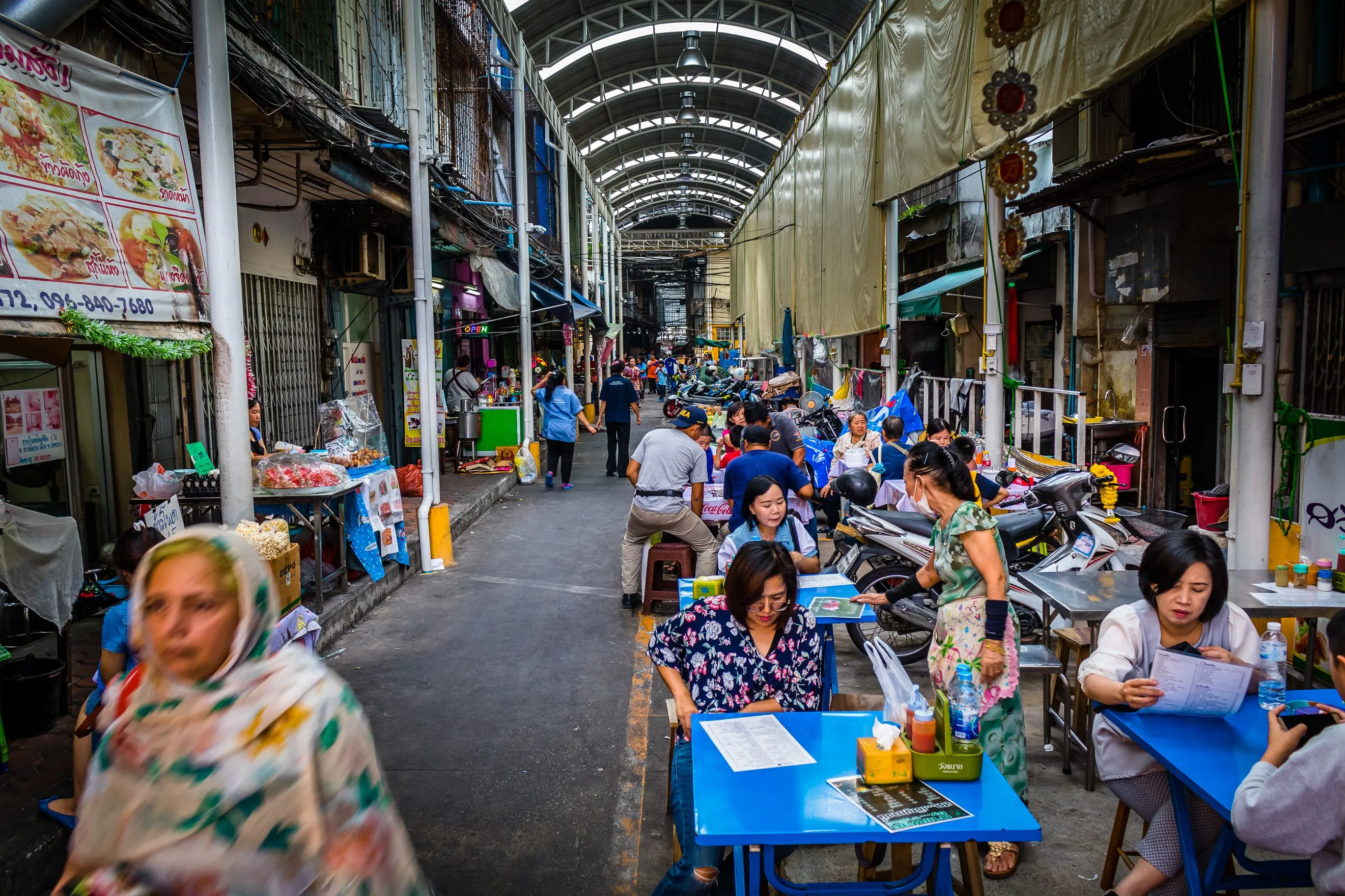 Explore a bustling street market in Chiang Mai, Thailand, with vibrant stalls and diverse crowds