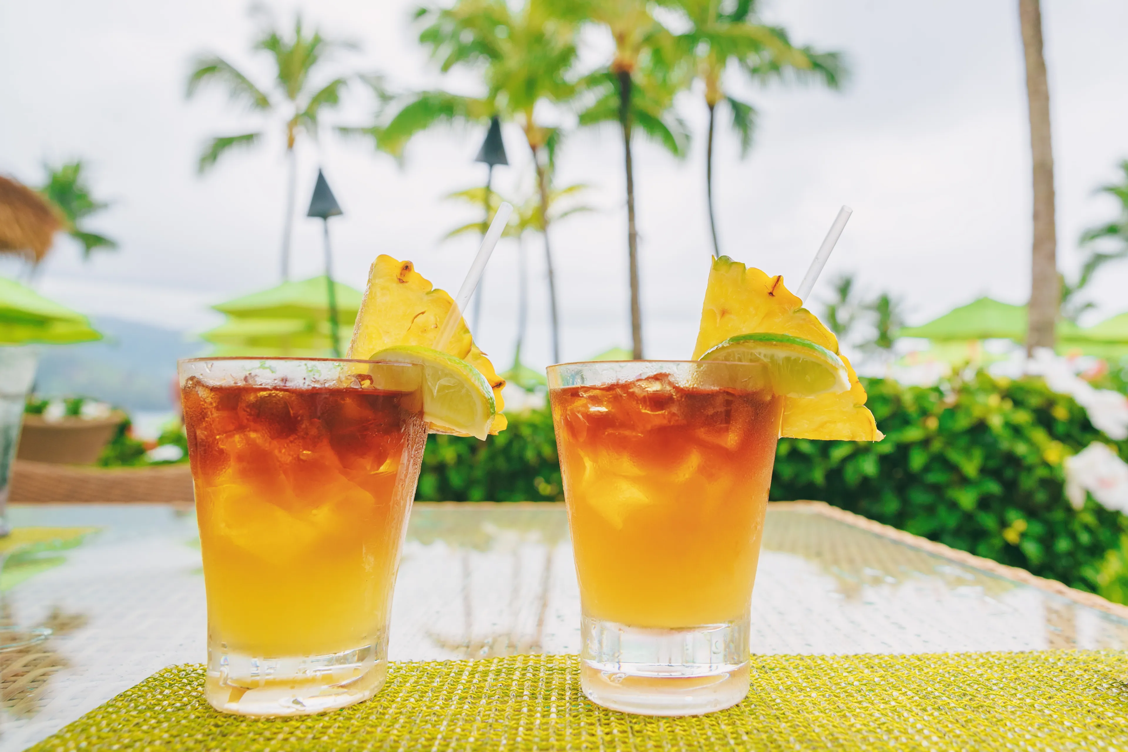 Hawaii mai tai drinks at resort hotel restaurant. Famous hawaiian rum based drink cocktails with view of beach, Hawaii tourist summer vacation destination