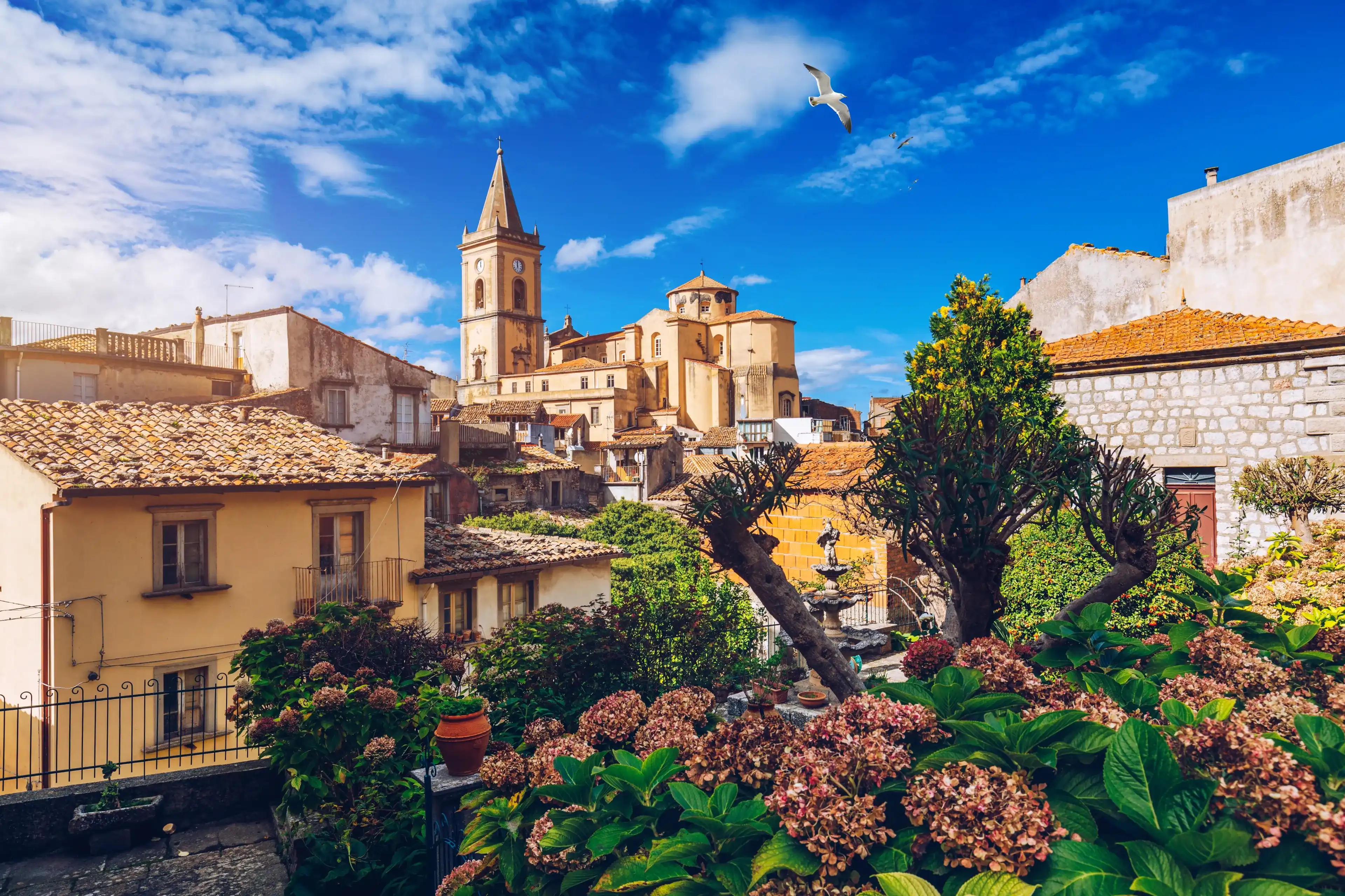 Picturesque street with the Duomo in the background in Novara di Sicilia, Sicily, Italy. Amazing cityscape of Novara di Sicilia town. Mountain village Novara di Sicilia, Sicily, Italy. Picturesque street with the Duomo in the background in Novara di Sicilia, Sicily, Italy. Amazing cityscape of Novara di Sicilia town. Mountain village Novara di Sicilia, Sicily, Italy.