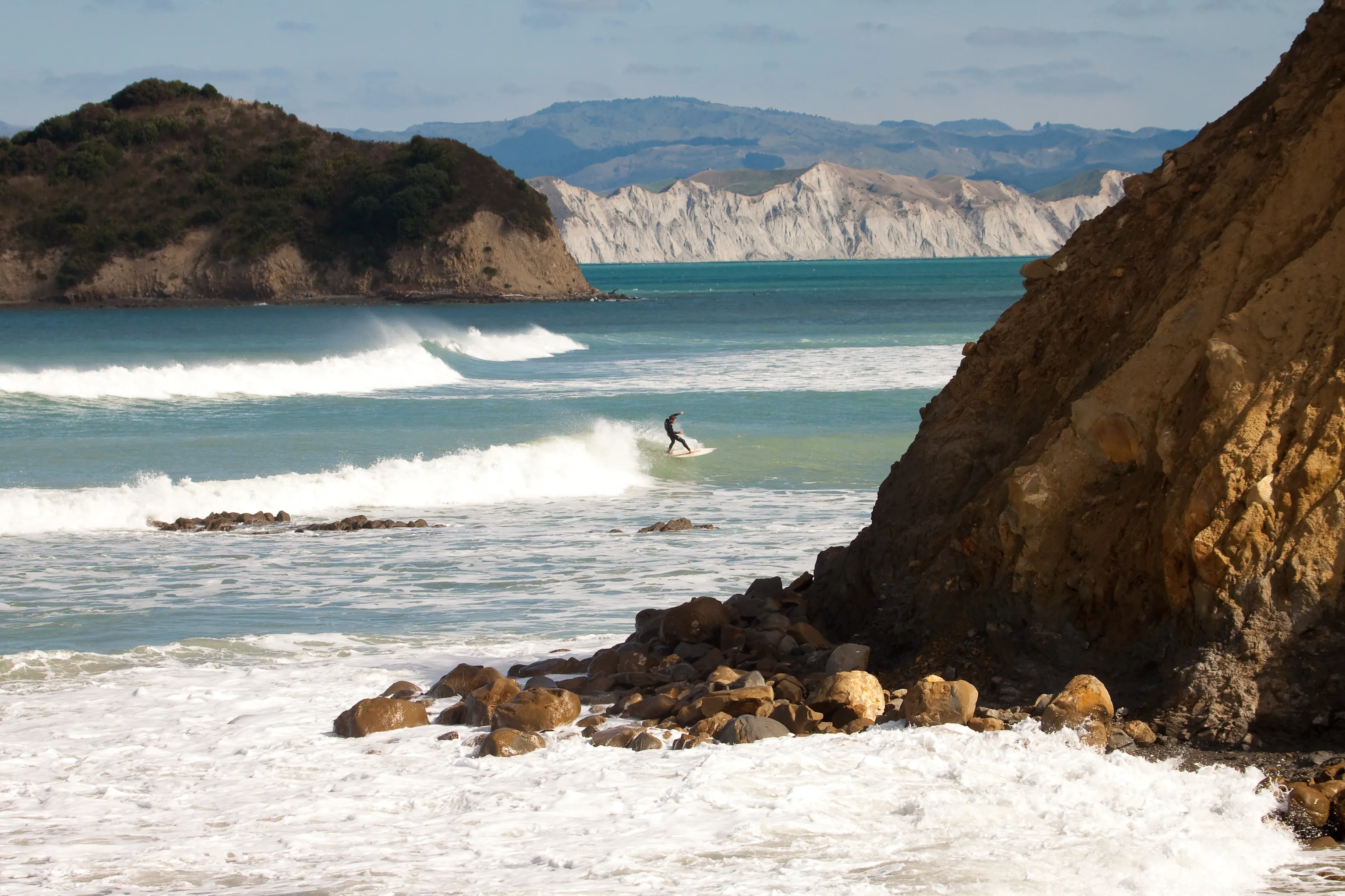 Surfers at Sponge Bay Island, Gisborne, New Zealand 