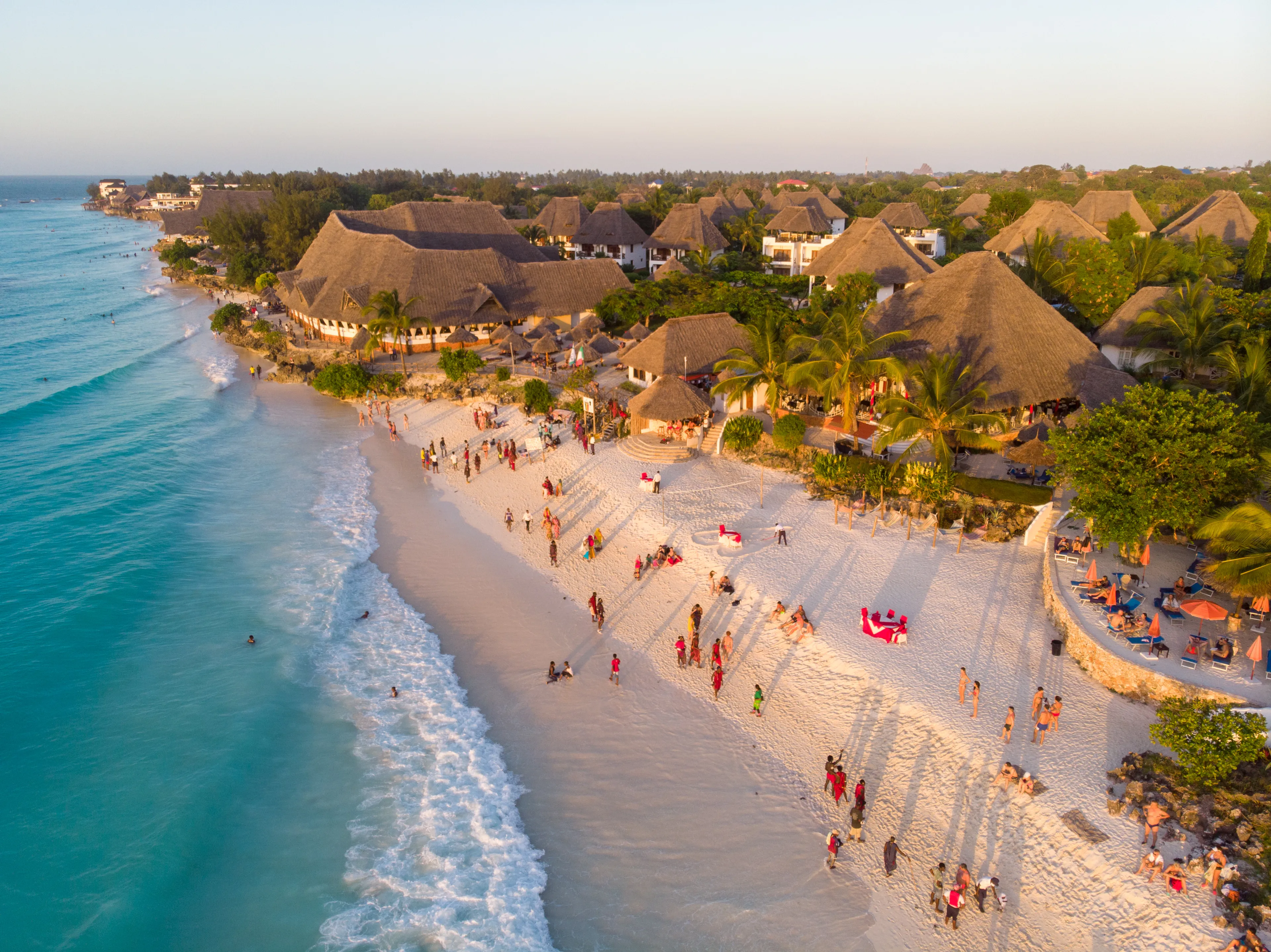 Aerial Shot on Zanzibar a beautiful sunset with people Walking on the Nungwi beach in Zanzibar in Tanzania