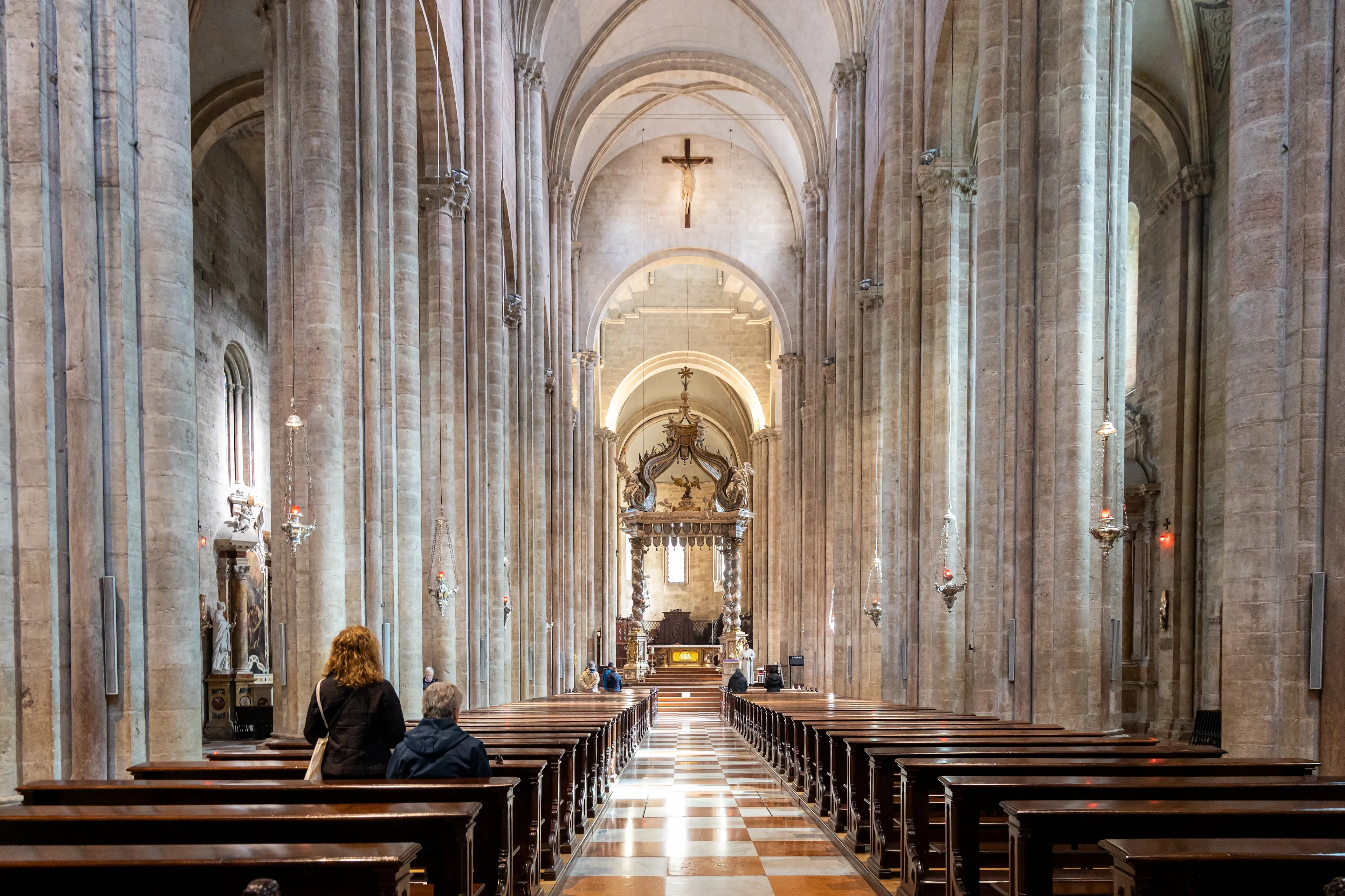 Trento, Trentino-Alto Adige, Italy - Mar 8th, 2024: People praying inside of Cathedral of San Vigilio