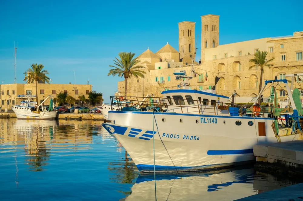 Molfetta, Italy, 2 of November 2024, small fishing port at sunset, old town buildings, fishing boats