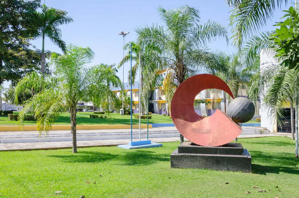 PORTO VELHO, BRAZIL - JUNE 15, 2017: Sculpture in front of the city hall of Porto Velho, surrounded by grass and trees. Red sculpture made of metal, round with a pointed tip and the other oval shaped.