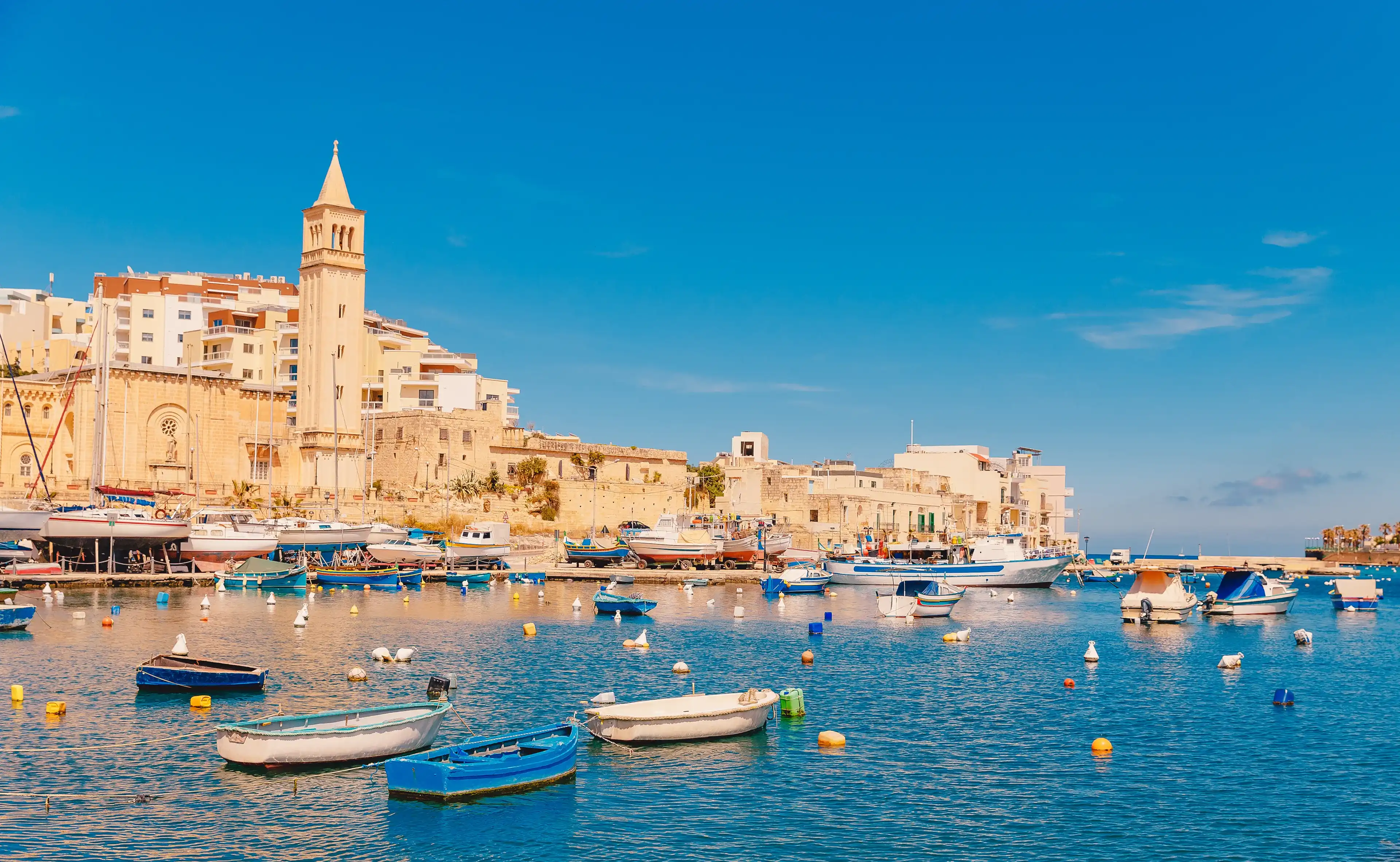 City Marsaskala Malta summer harbour Fishing boats in water mediterranean sea blue.