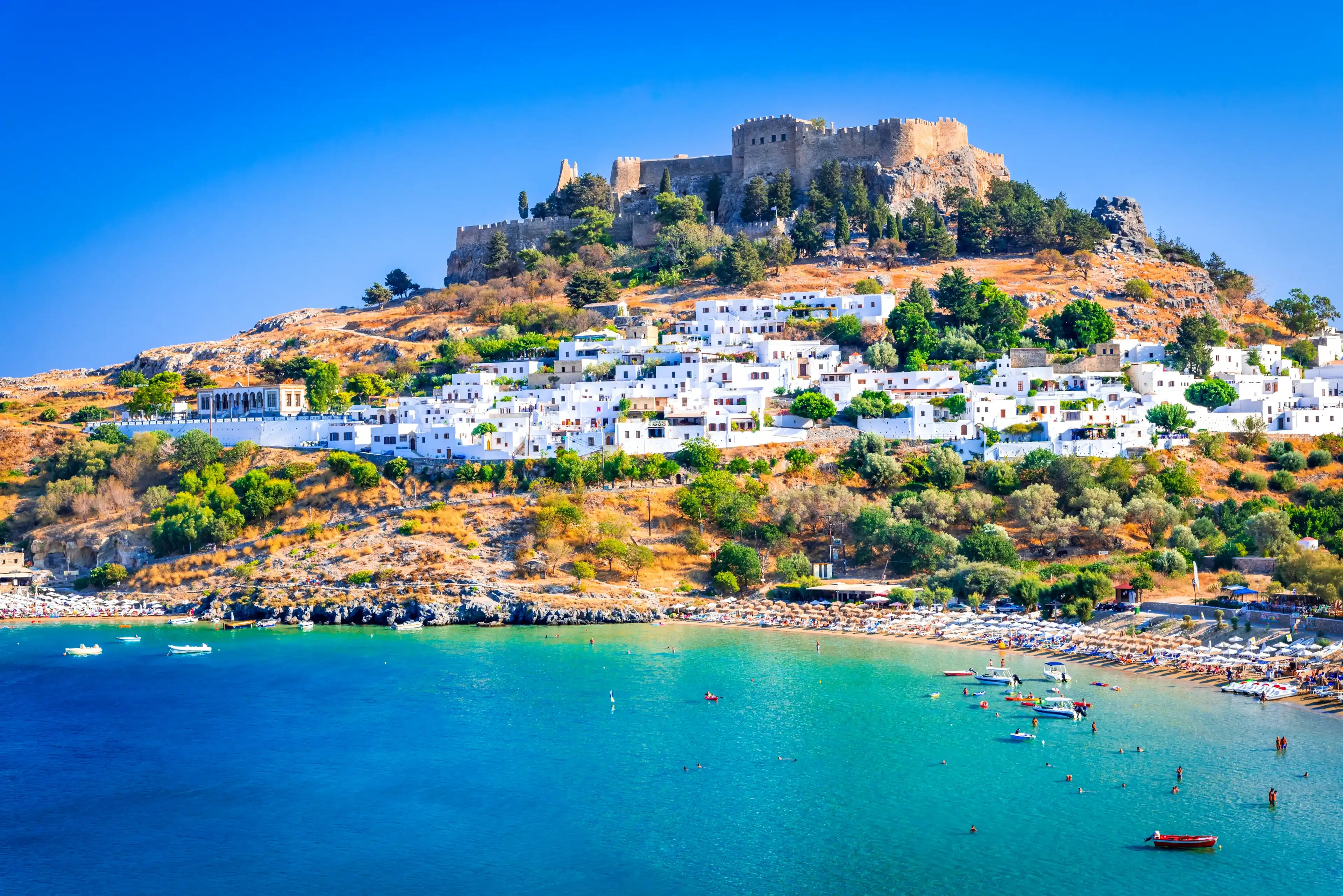 Rhodes, Greece. Lindos small whitewashed village and the Acropolis, scenery of Rhodos Island at Aegean Sea. Rhodes, Greece. Lindos small whitewashed village and the Acropolis, scenery of Rhodos Island at Aegean Sea.