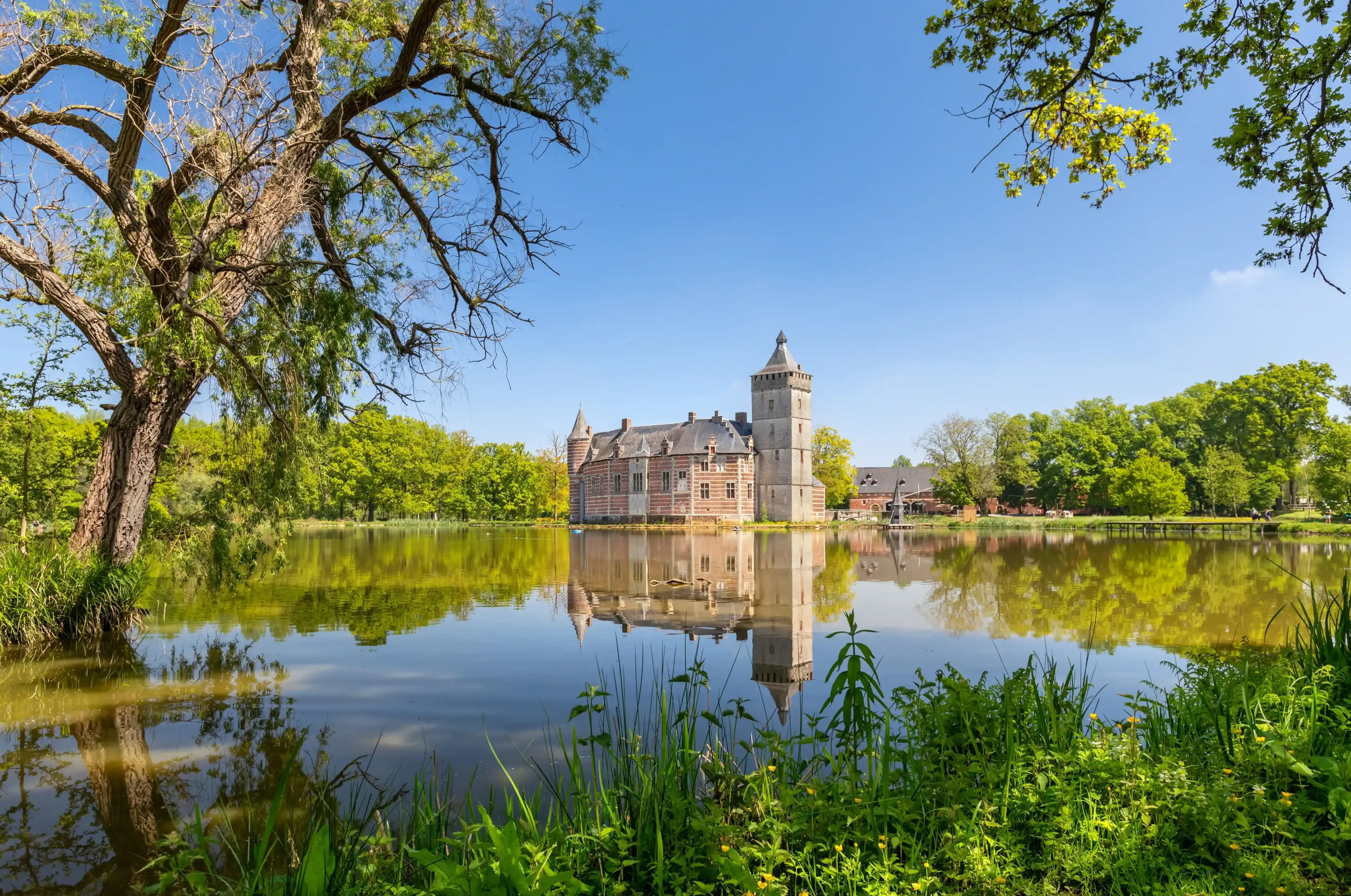 Holsbeek, Belgium - May 06 2022: View of historic Castle Van Horst with lake and park in summer day