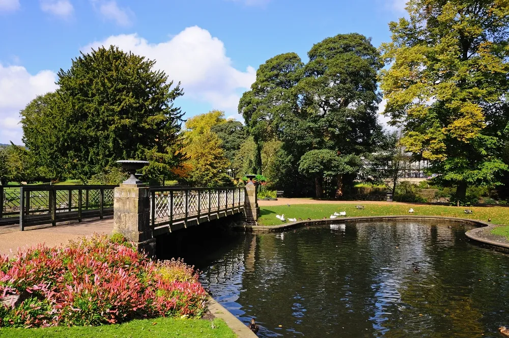 BUXTON, UNITED KINGDOM - SEPTEMBER 7, 2014 - Footbridge across the lake in the Pavilion Gardens, Buxton, Derbyshire, England, UK, Western Europe, September 7, 2014.