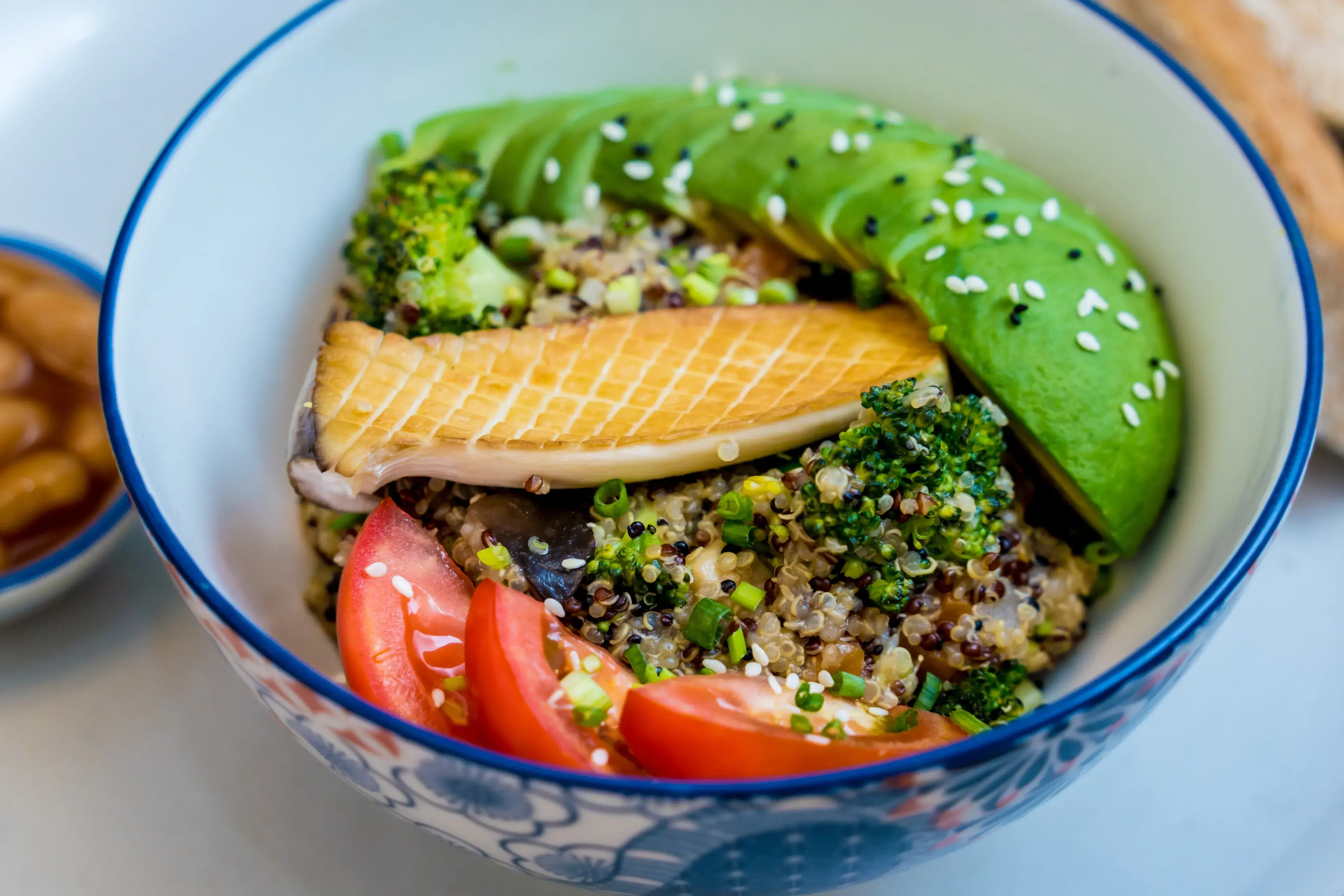 Healthy quinoa bowl with avocado, mushrooms and fresh vegetables