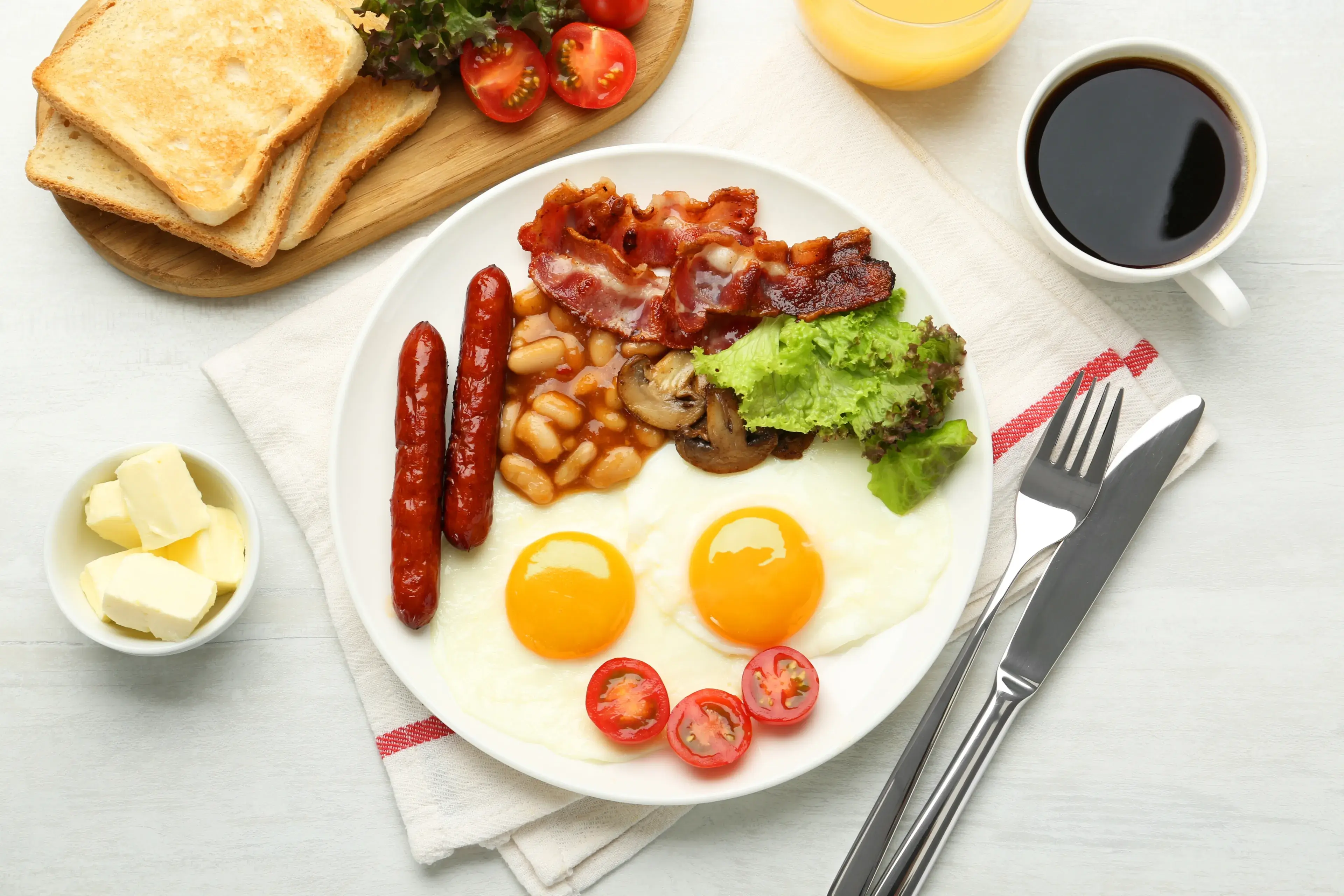 Delicious breakfast with sunny side up eggs served on white table, flat lay