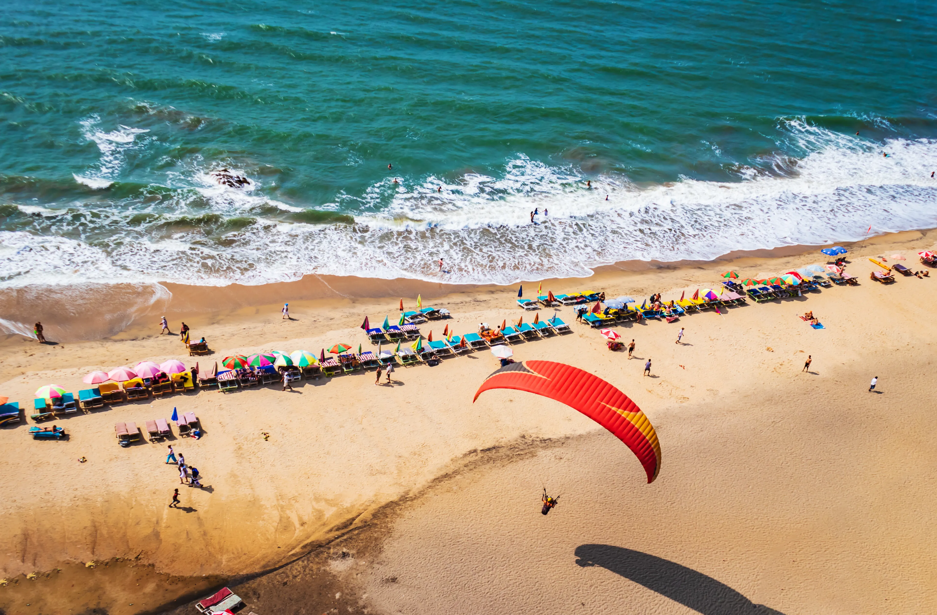 top view of beach in Goa India vagator beach. people taking sunbath on the beach on shacks 