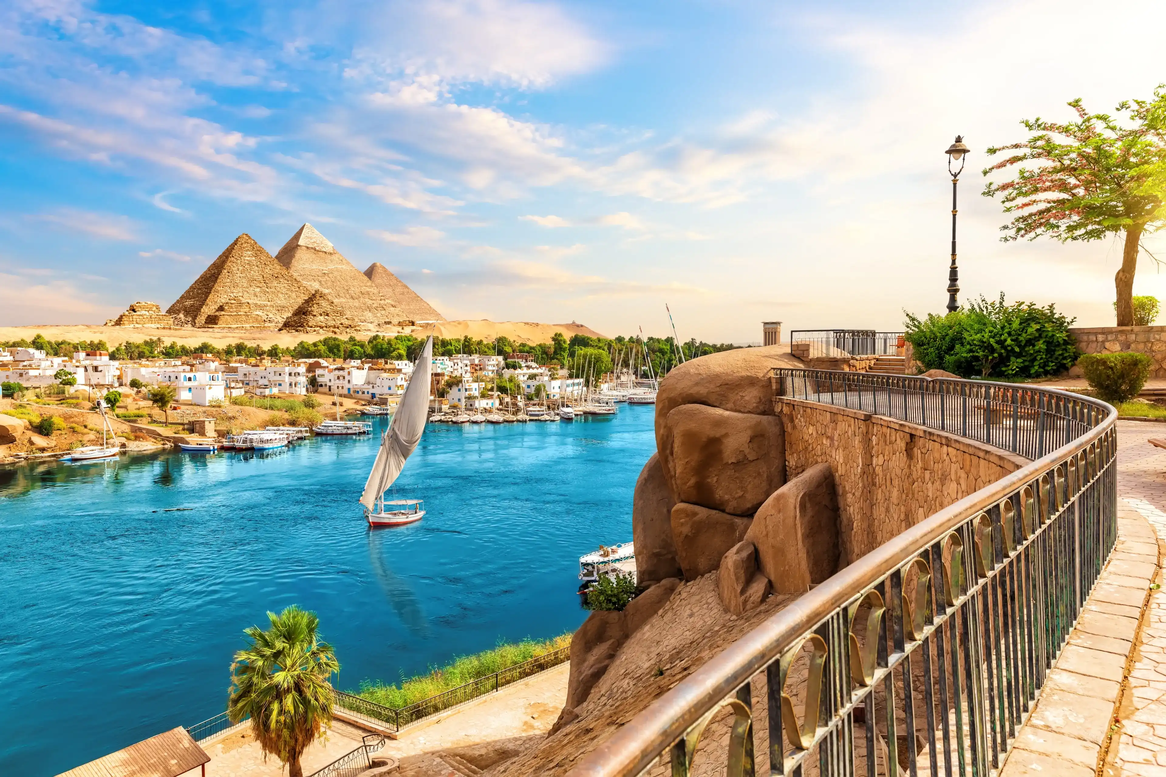 Skyline view of Aswan with sailboats in the Nile on the way to pyramids, Egypt Skyline view of Aswan with sailboats in the Nile on the way to pyramids, Egypt