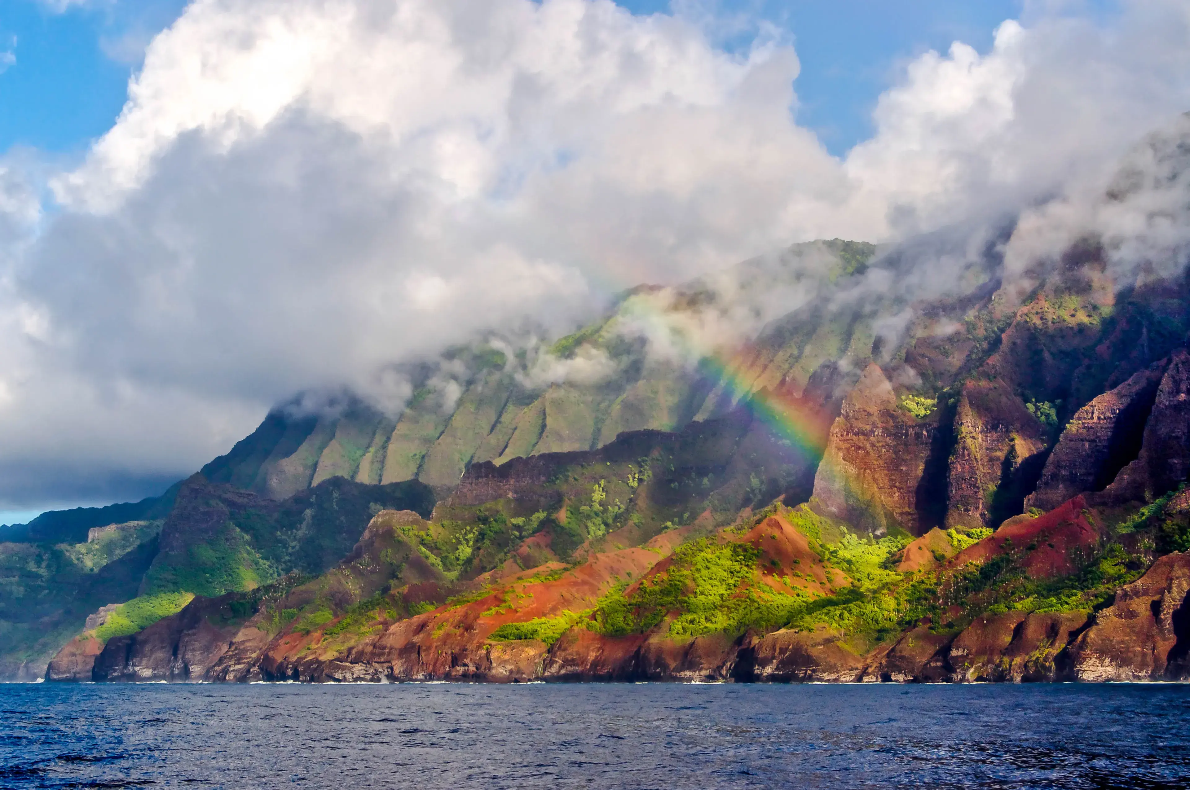 A rainbow links the clouds to the Na Pali Coast of Kauai, Hawaii. A rainbow links the clouds to the Na Pali Coast of Kauai, Hawaii.