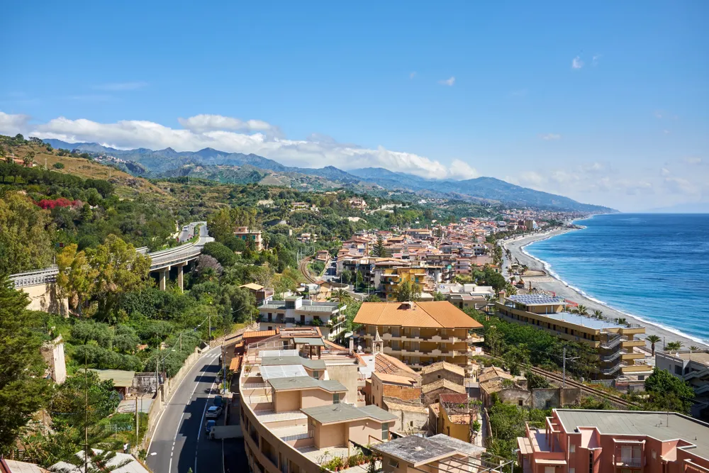 view of the village of Santa Teresa di Riva on the Ionic Coast of SIciliana and the Strait of Messina in the background