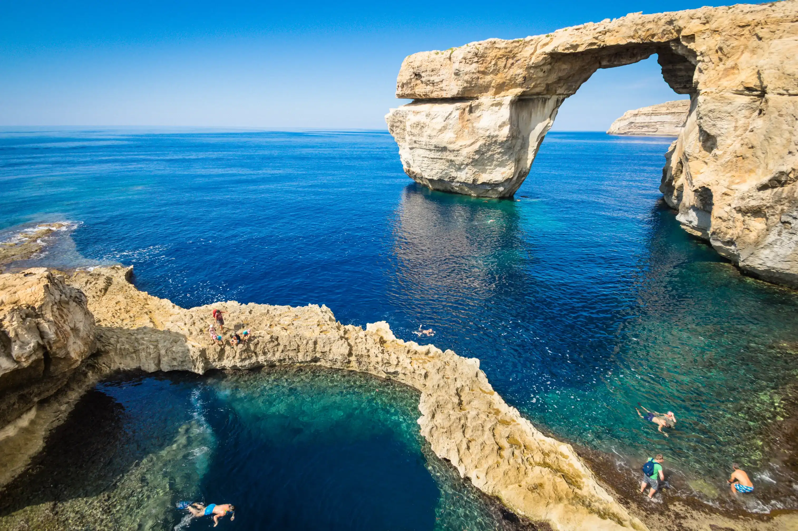 The Azure Window in Gozo island - Mediterranean nature wonder in beautiful Malta - Unrecognizable touristic scuba divers - World famous rock formation landmark collapsed after sea storm