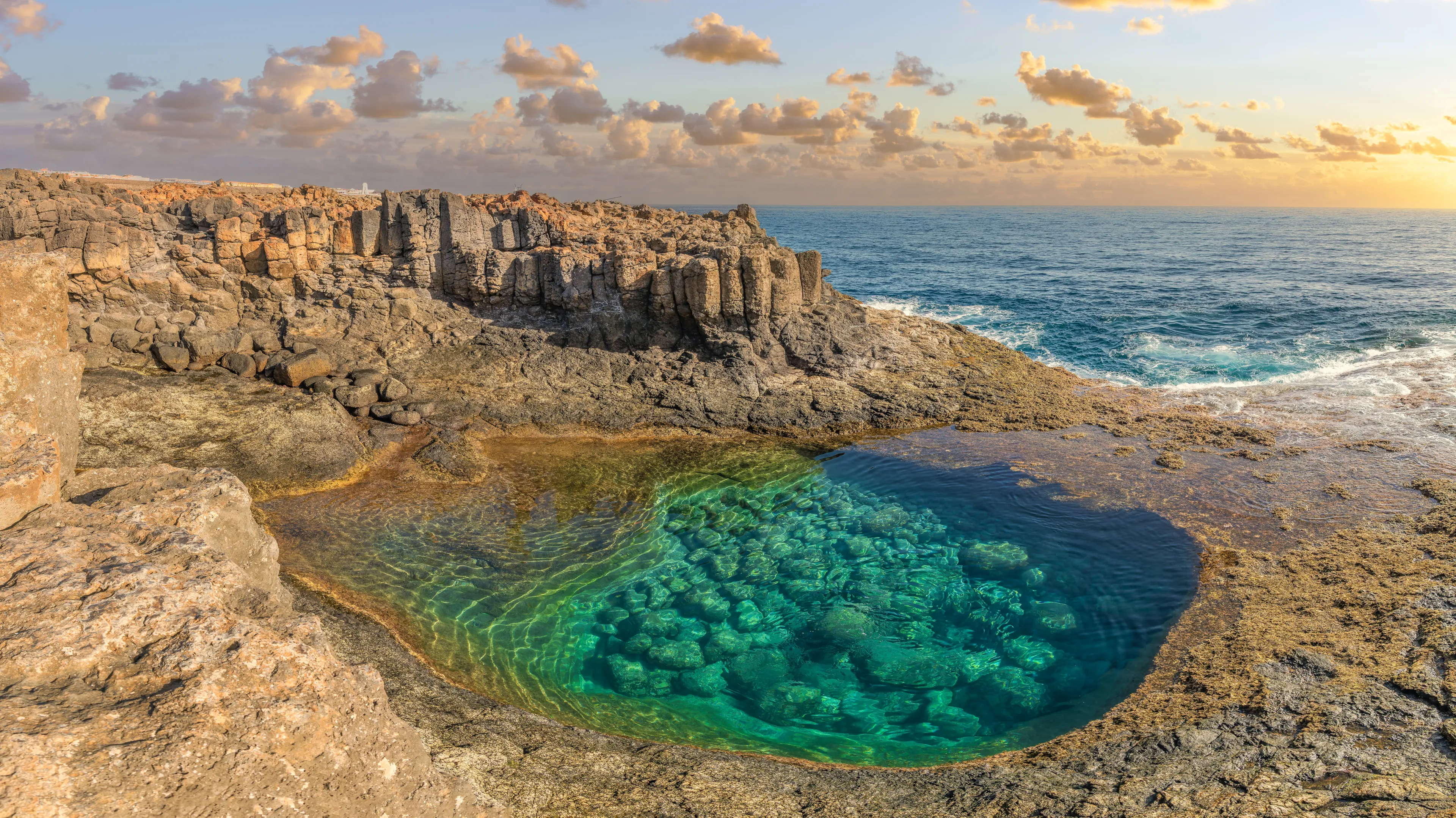 Discover the natural pools at Caleta de Fuste, Fuerteventura: an oasis of calm with crystal-clear waters, framed by volcanic cliffs and idyllic landscapes.